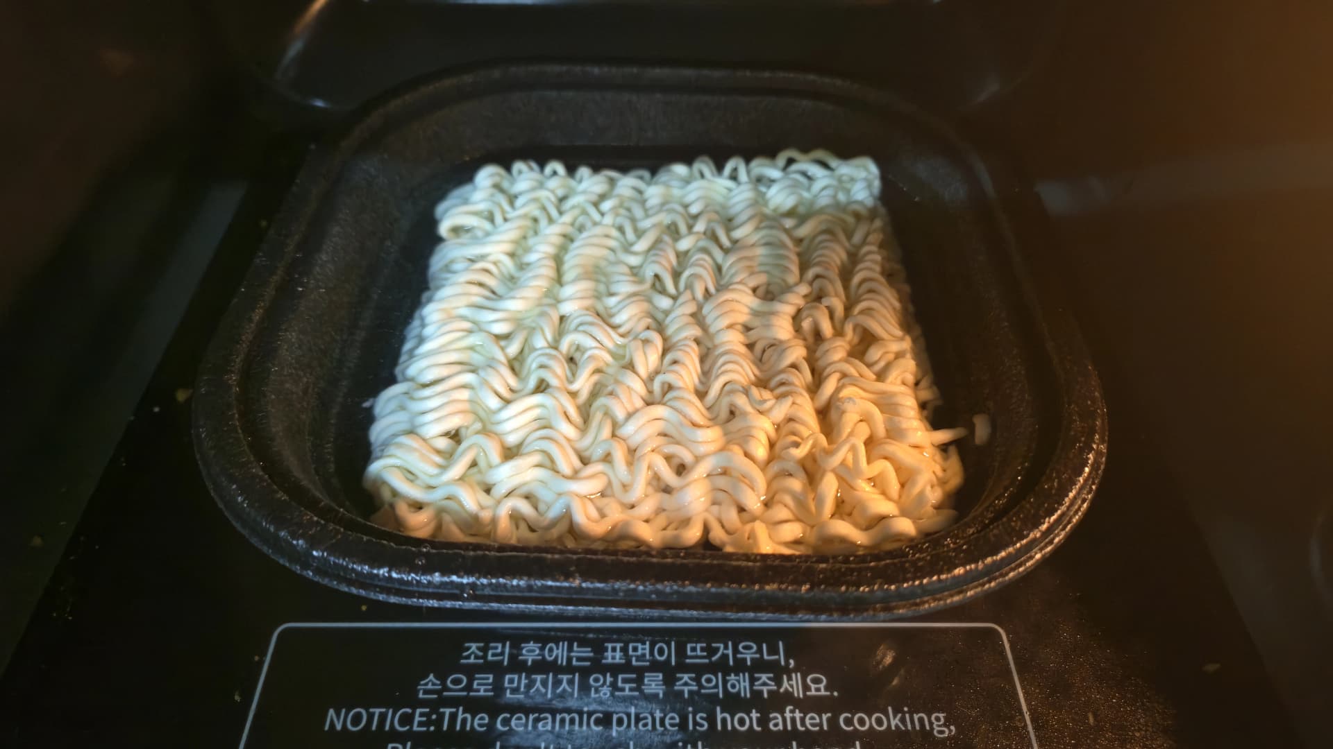 مىكروتولقۇنلۇق پەچتە پىشۇرۇلىۋاتقان بۇلداك بوكۇممېن - قارا تەخسىگە سۇ ۋە نېگىزلىك سېلىپ قىزدۇرۇلىۋاتىدۇ | 하이제이에스비