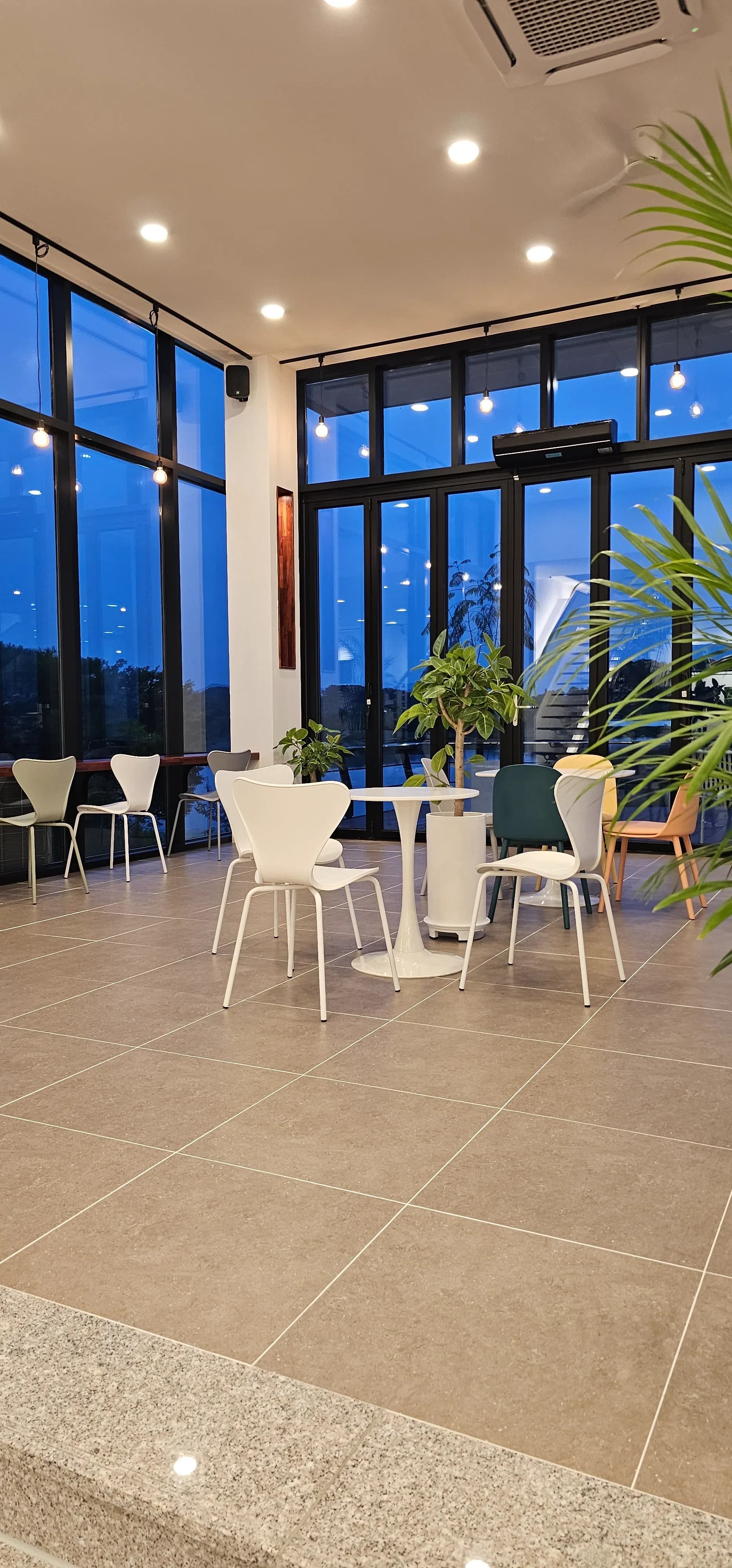 카페 반내 1층 통창 방향 — 유리벽 너머 바깥 조명이 비치는 모습