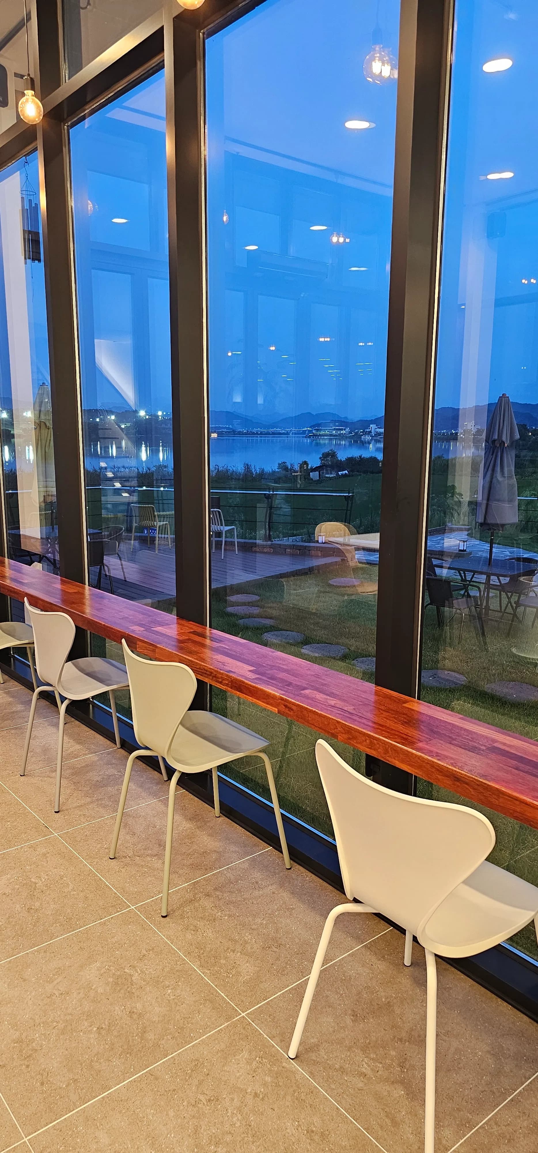 카페 반내 창가 바 좌석 — 전면 유리 너머로 남한강과 잔디밭이 보이는 핵심 좌석