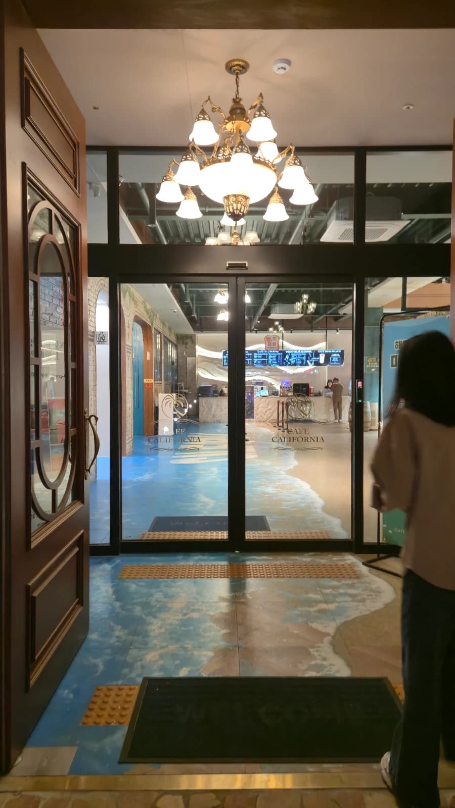 카페 캘리포니아 자동문 입구 바닥 바다 그림과 샹들리에