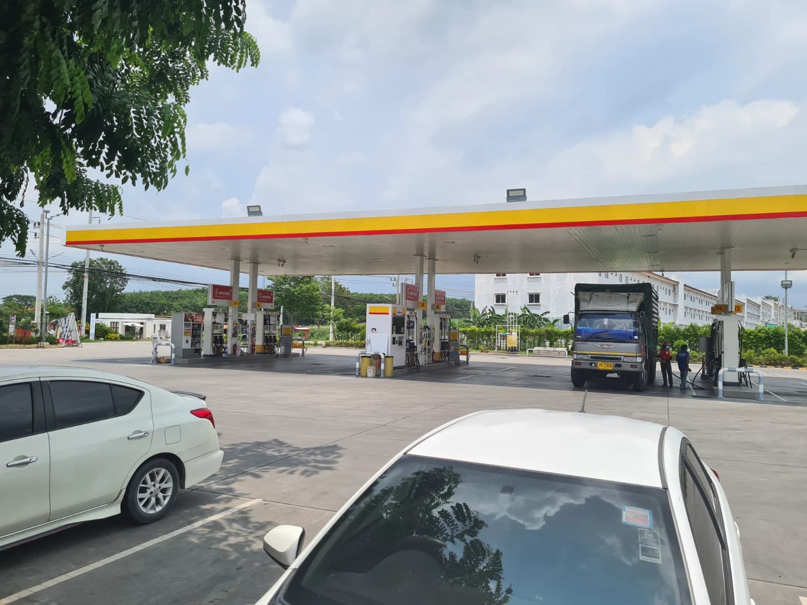 태국 라용 Shell 주유소 전경, 노란 조개 로고와 주유기가 보이는 풍경