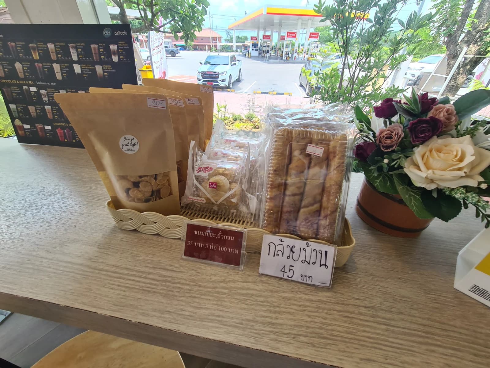 delicafé 창가 테이블 위 태국 전통 간식, 클루아이뭄 바나나 롤과 카놈삐아 녹두 페이스트리