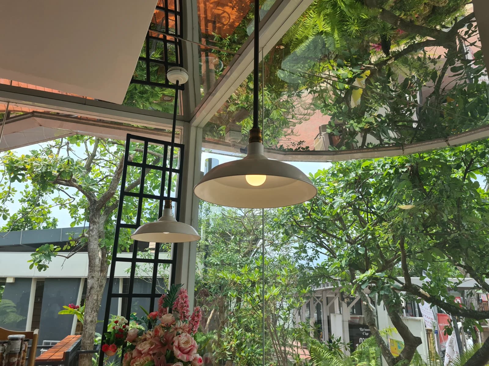 delicafé 천장 유리와 나뭇가지, 조명이 매달린 아늑한 카페 내부