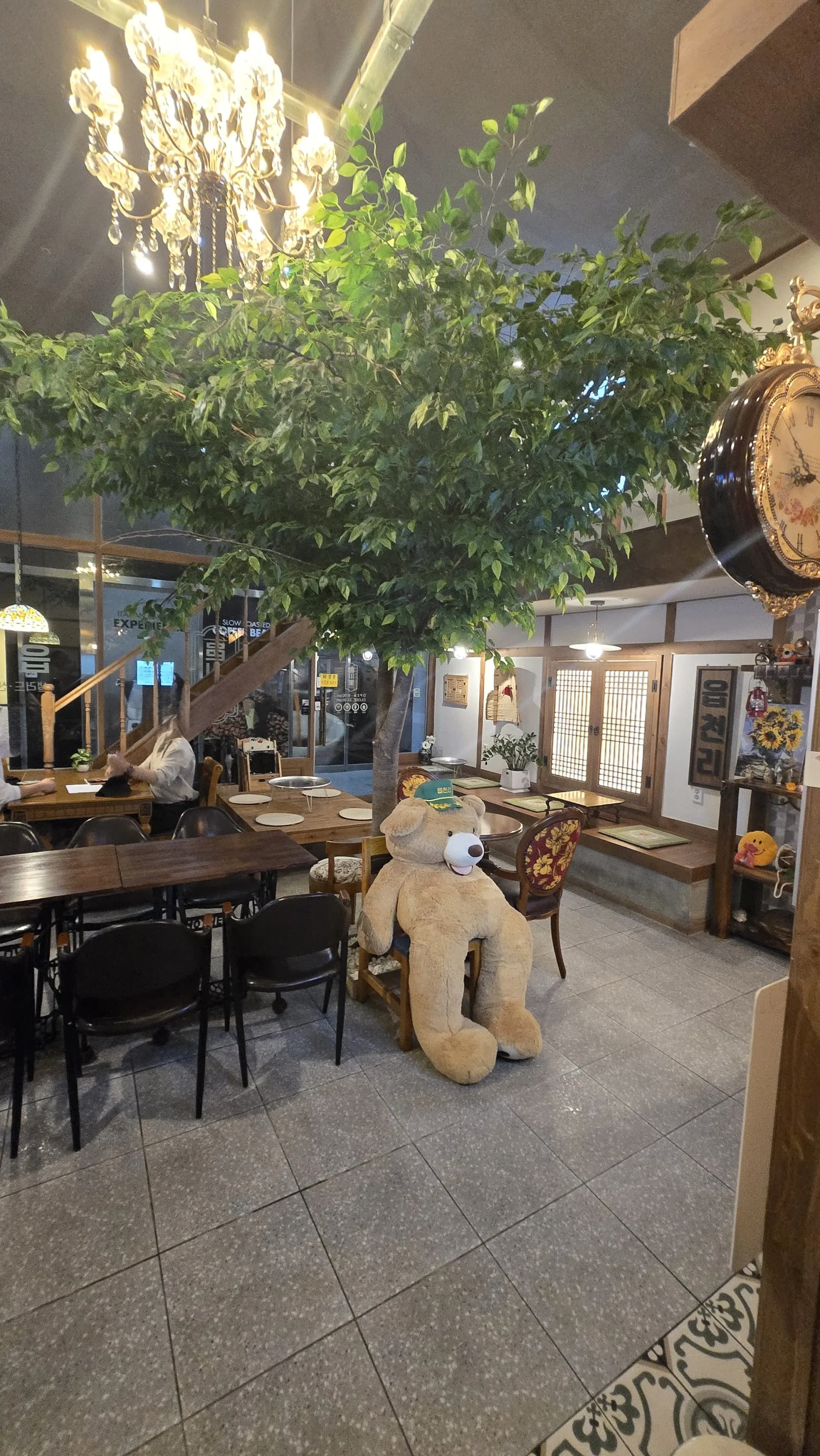 읍천리382 매장 내부 전경 — 큰 나무, 샹들리에, 전통 문살, 해바라기 장식, 곰 인형이 있는 레트로 인테리어 | 하이제이에스비