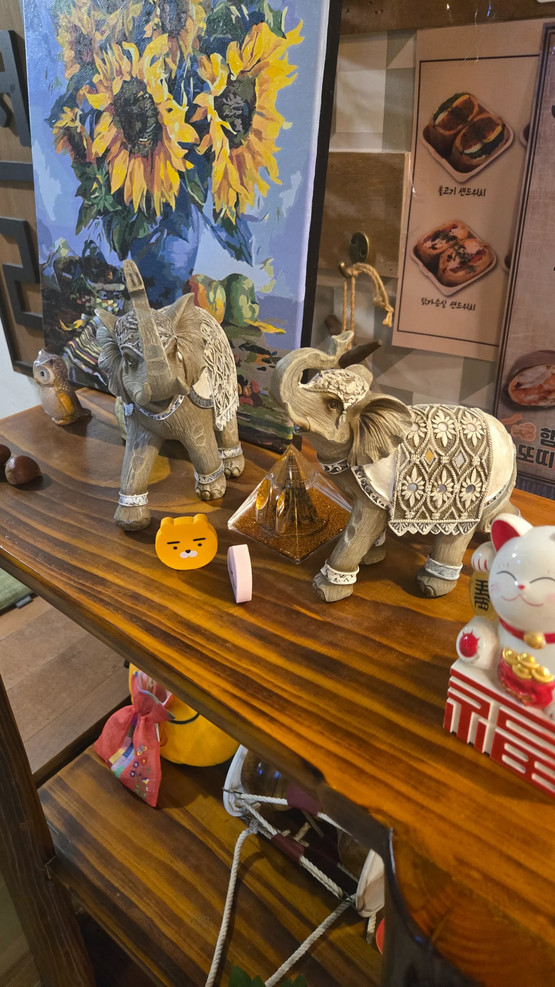 읍천리382 선반 위 빈티지 소품 — 코끼리 장식, 해바라기 그림, 카카오프렌즈 라이언, 마네키네코 | 하이제이에스비
