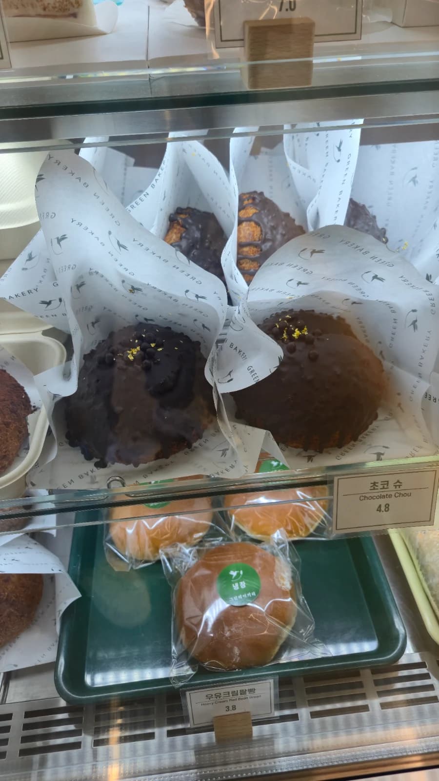 Green Bakery chocolate choux with gold leaf and milk cream bun nearby