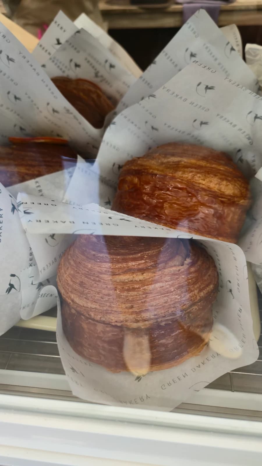 Green Bakery croffin with branded wrapper and glossy surface