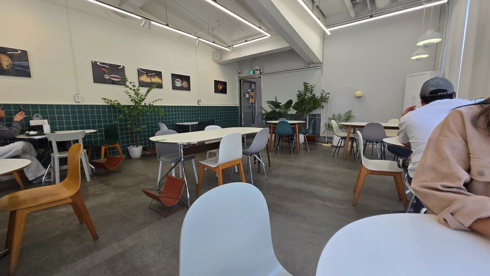 Green Bakery seating area with comfortable spacing and green tile walls