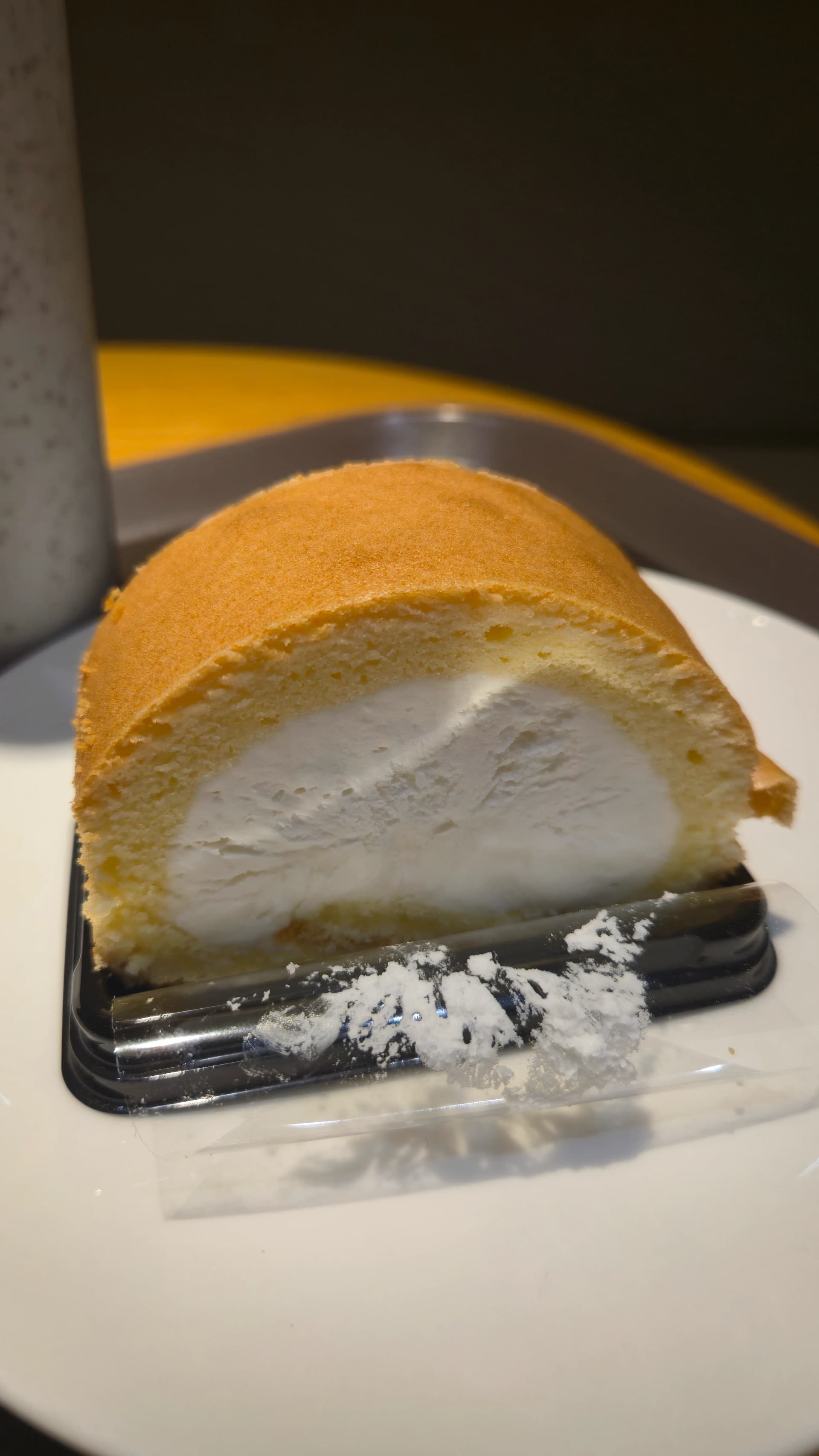 할리스 순수 우유 롤케이크를 한 입 먹은 단면 사진으로 생크림이 가득 차 있다