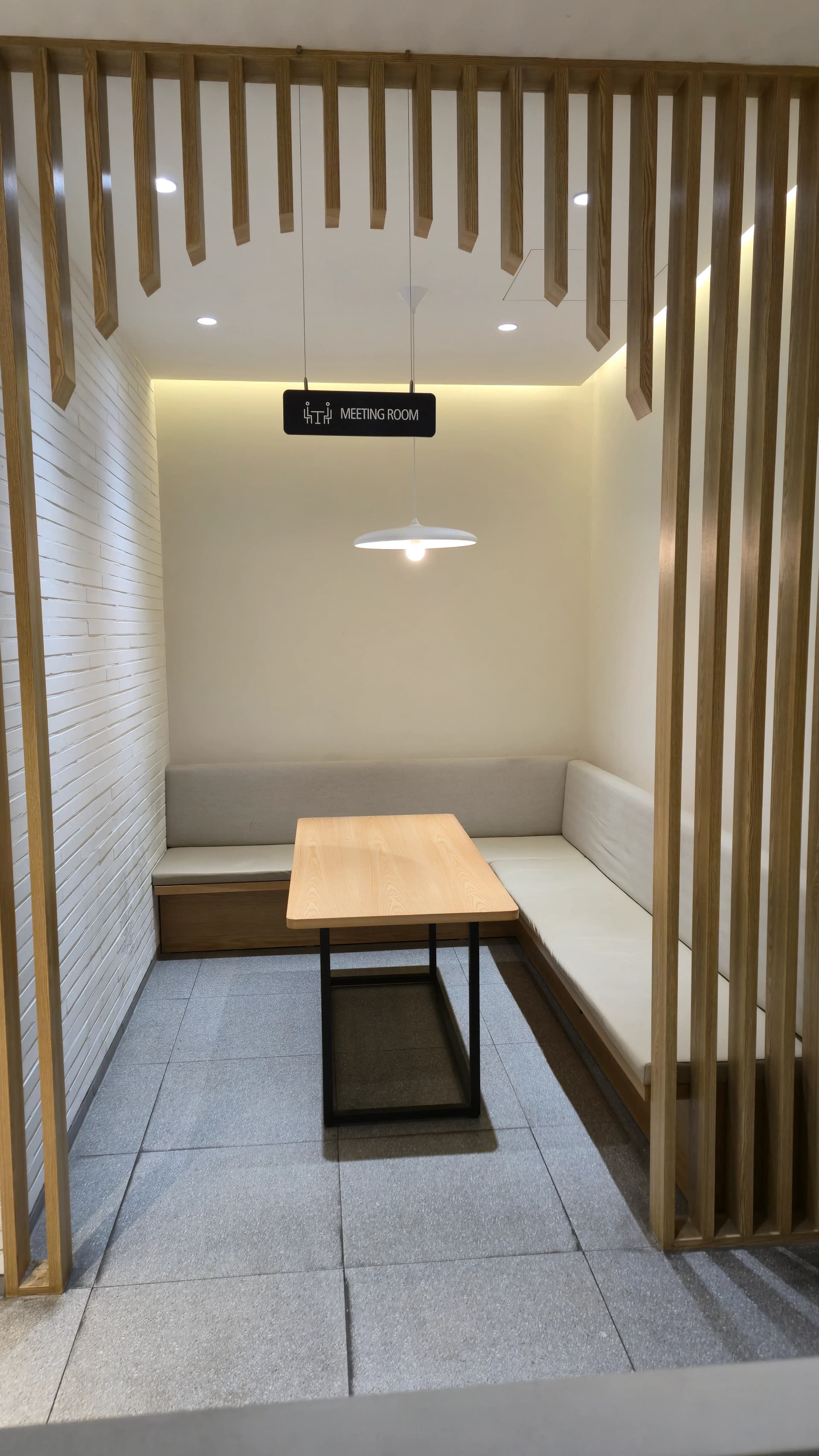 할리스 2층 미팅룸 공간으로 나무 격자 칸막이와 ㄱ자 소파가 보인다