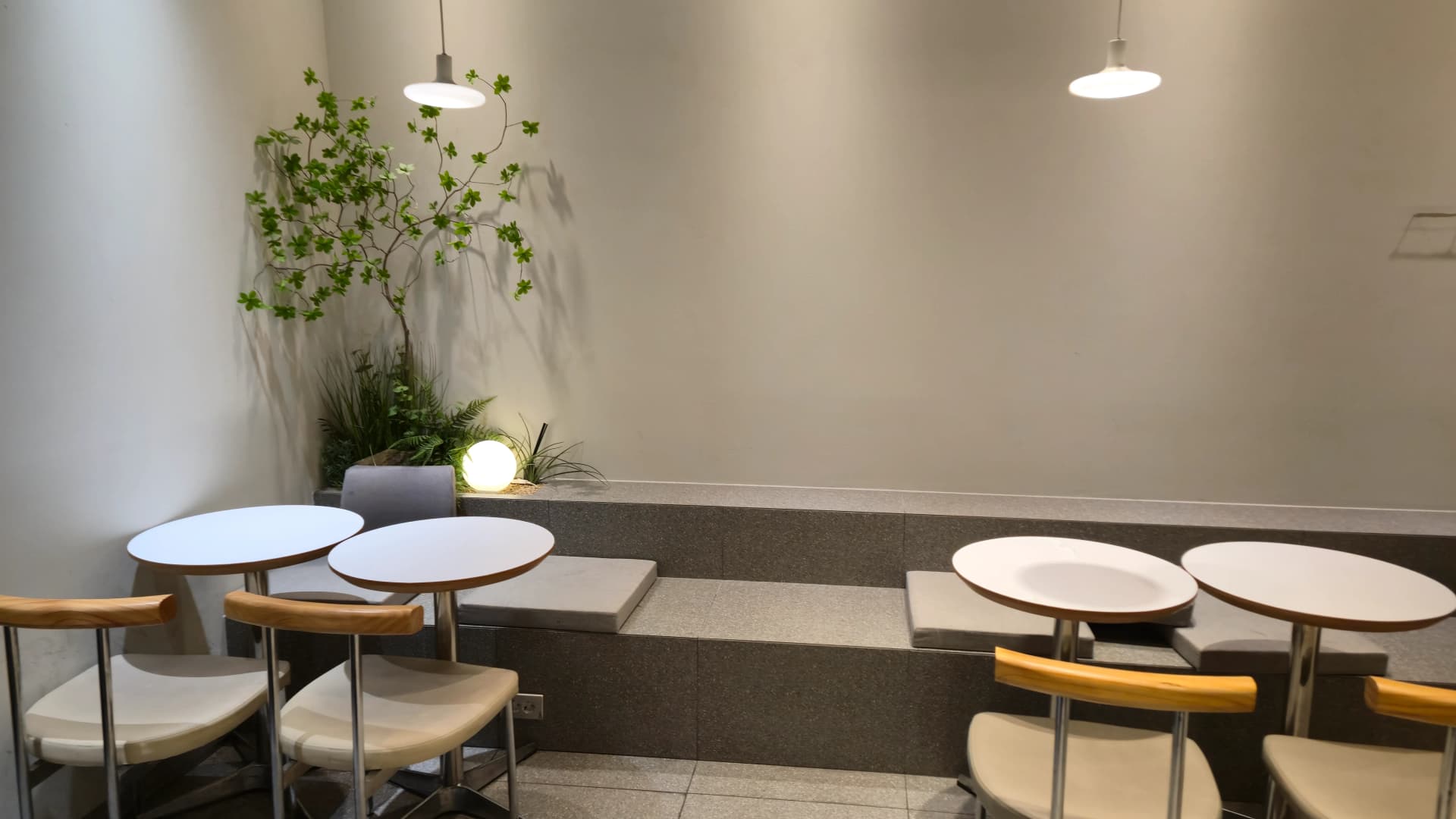 할리스 2층 안쪽 코너 계단식 좌석에 무드등과 초록 식물이 배치된 모습