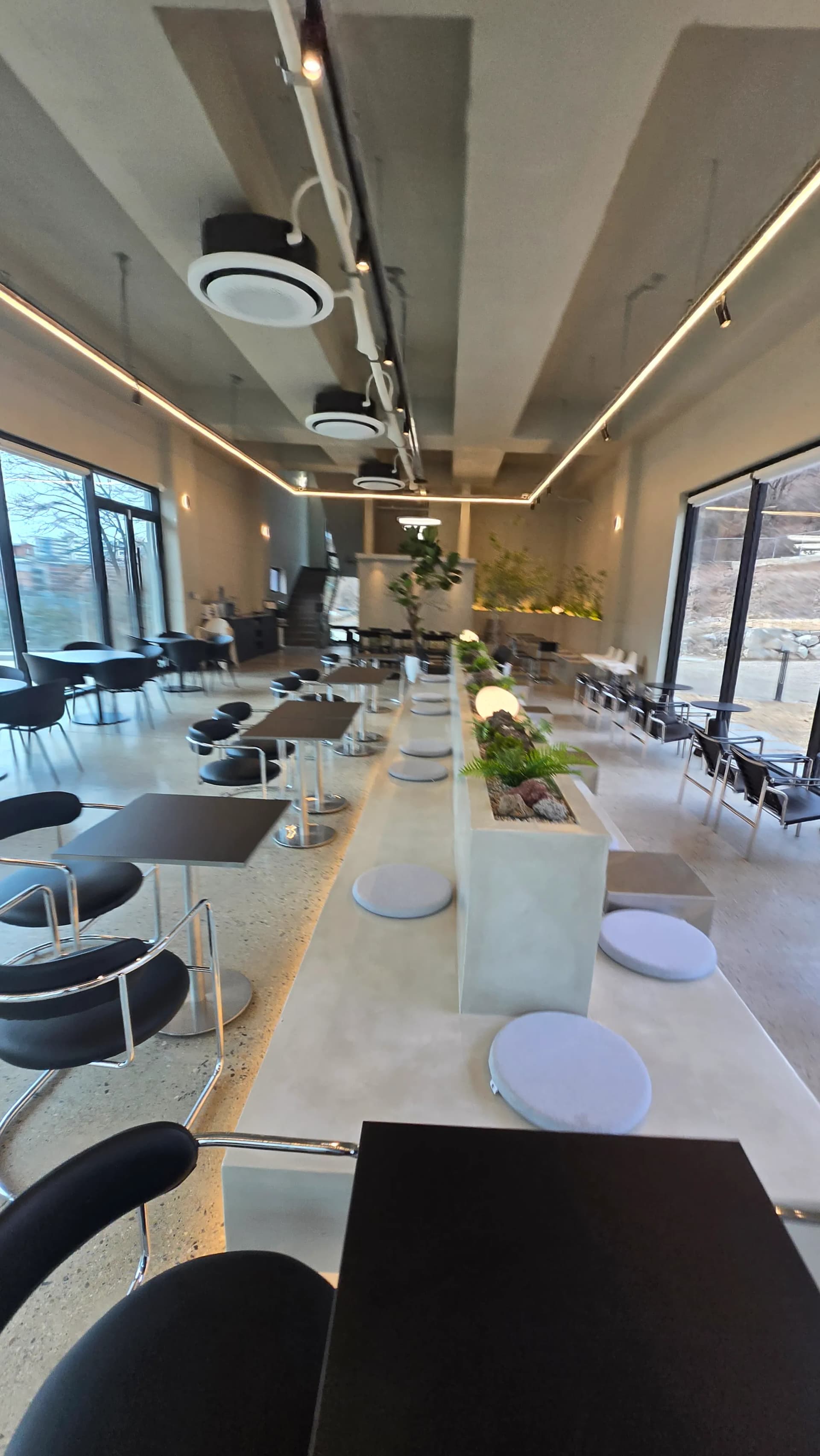 Інтер'єр кав'ярні MEON — просторий зал чорні столики непряме освітлення сучасний дизайн | 하이제이에스비