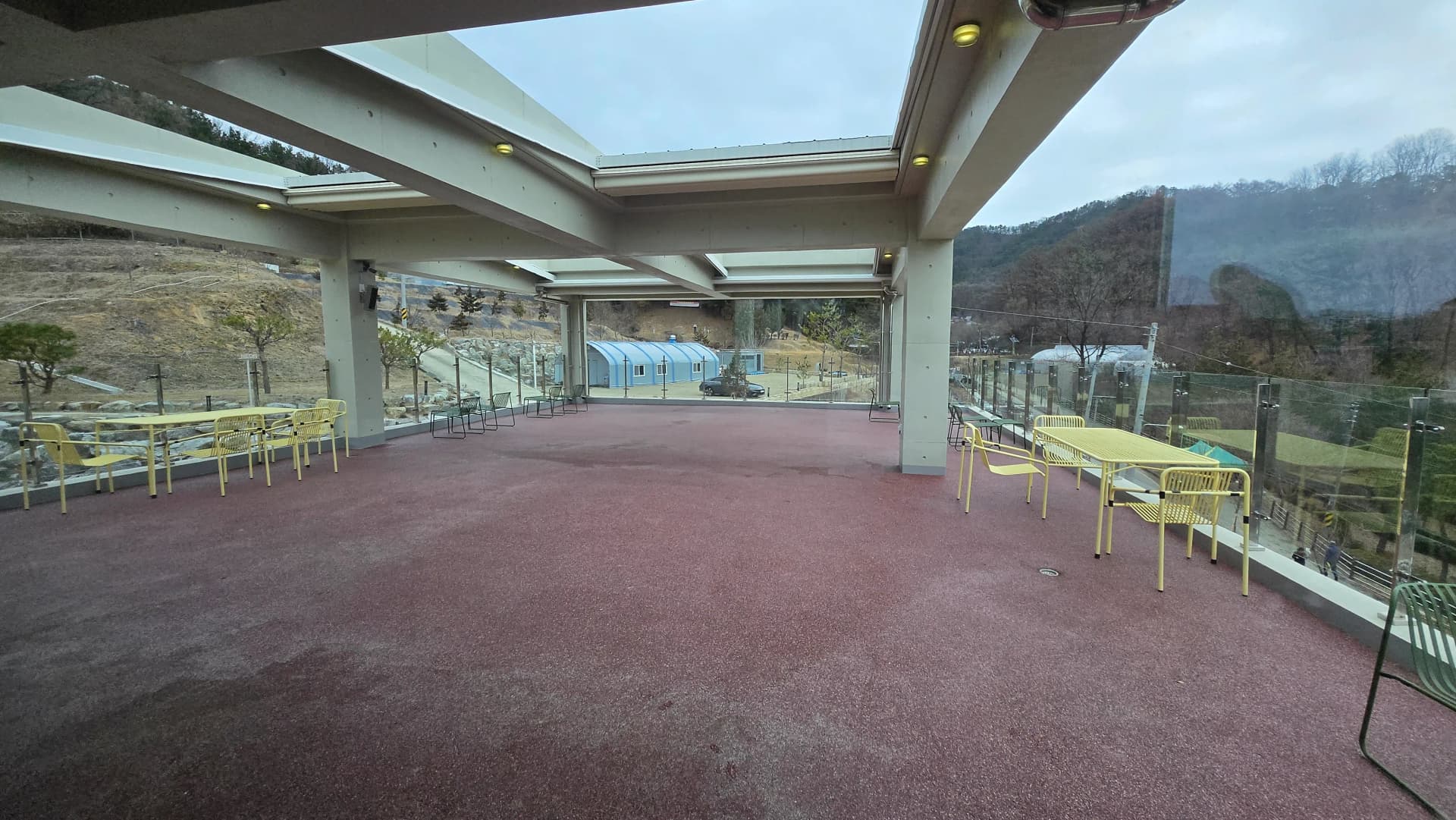 Кав'ярня MEON руфтоп загальний вигляд — червона підлога жовті стільці вид на гори | 하이제이에스비