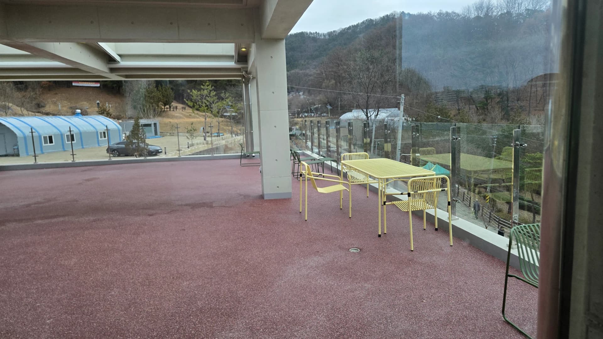 Кав'ярня MEON місця на руфтопі крупний план — жовті стільці скляні перила гірський краєвид | 하이제이에스비