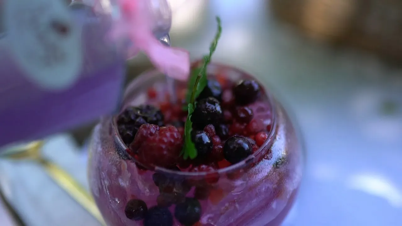 Purple berry syrup being poured over a fresh berry drink at Pa Dee in the Wild garden cafe