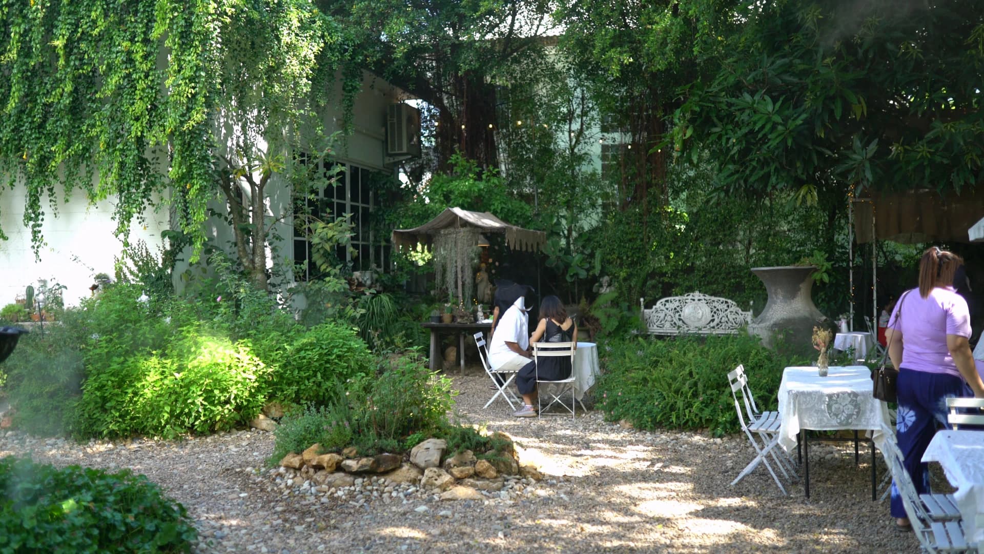 Guests relaxing under shady trees at outdoor tables in Pa Dee in the Wild
