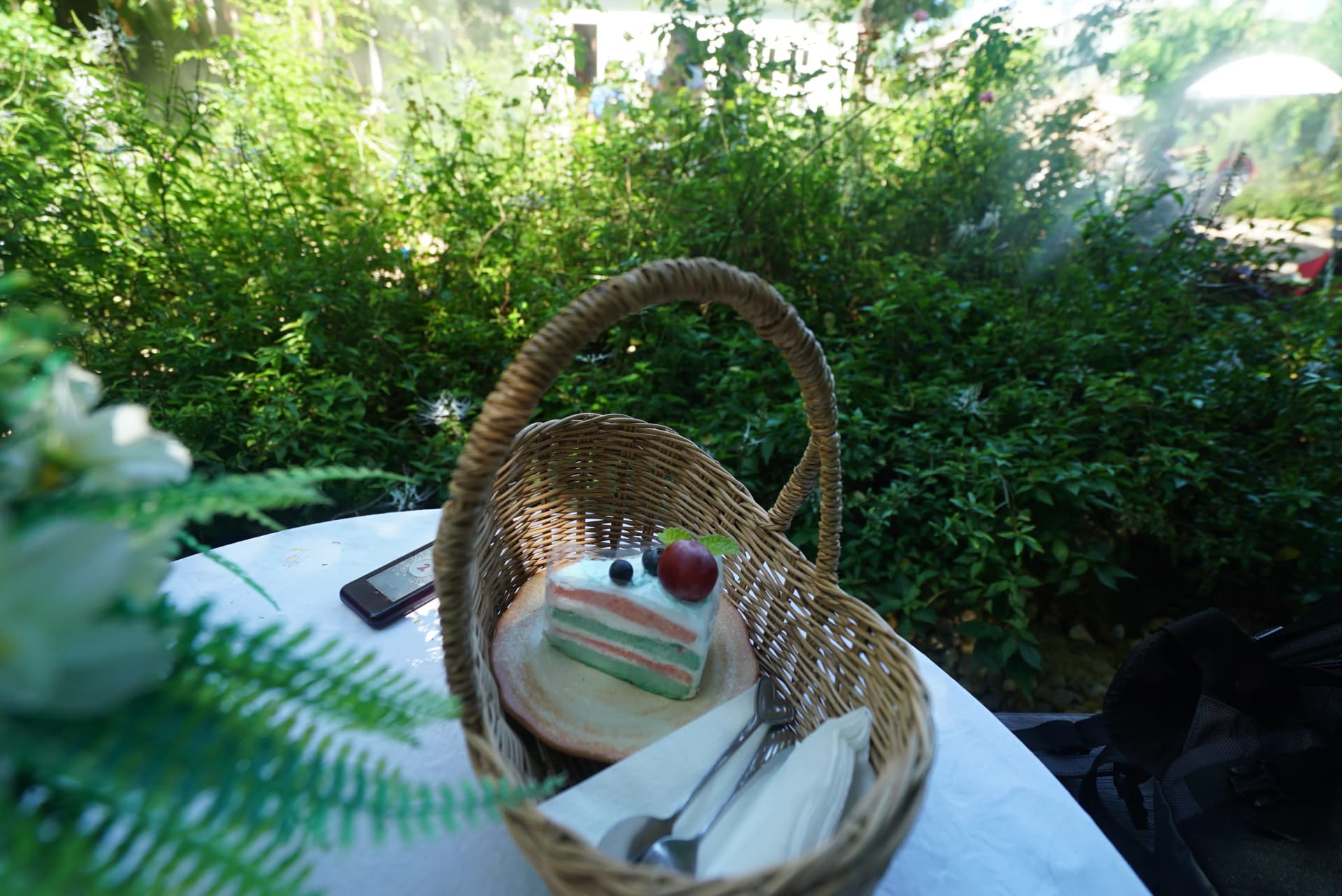 Homemade cake served in a rattan basket with lush garden backdrop at Pa Dee in the Wild