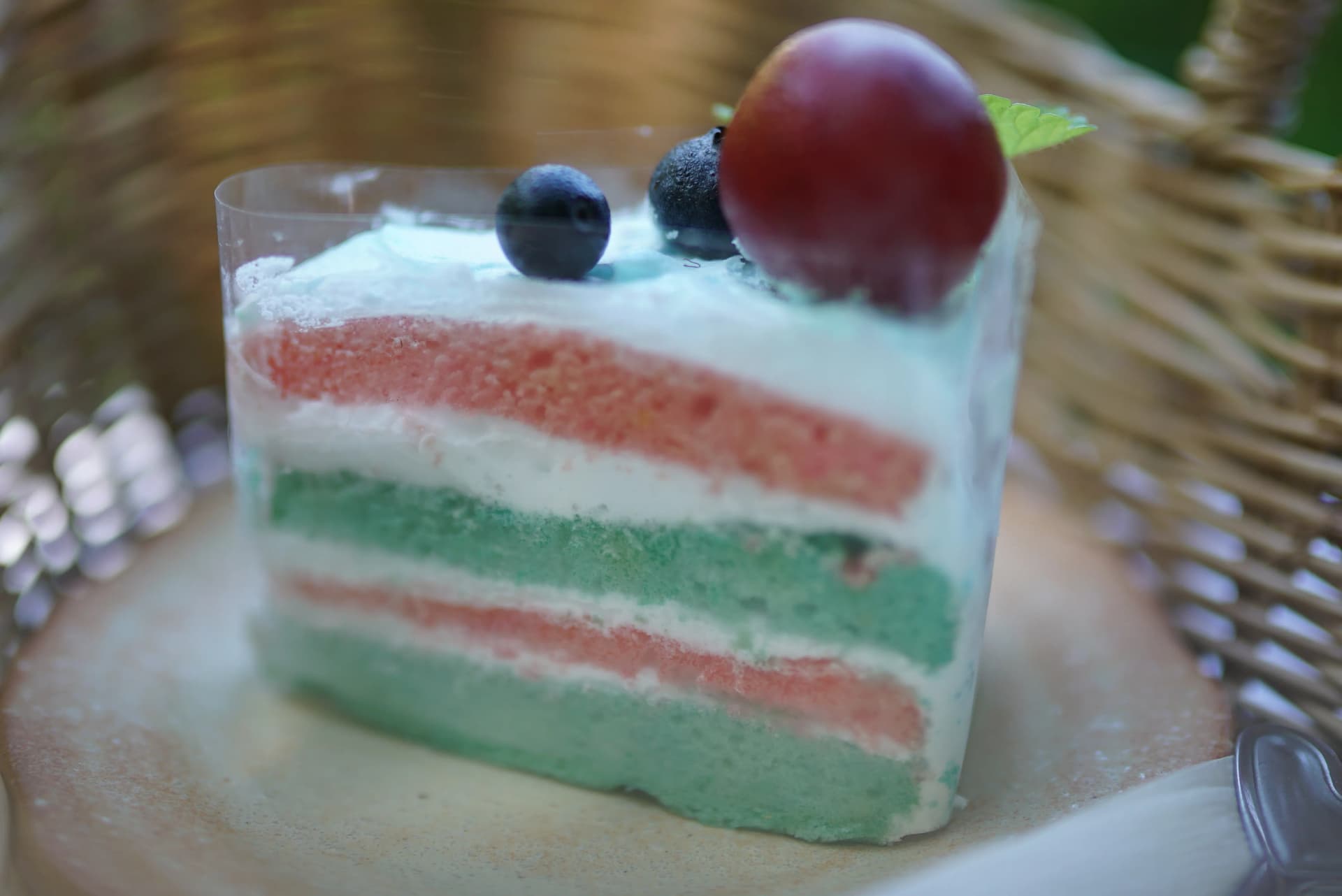 Three-layer pandan pink and white homemade cake full view from the side