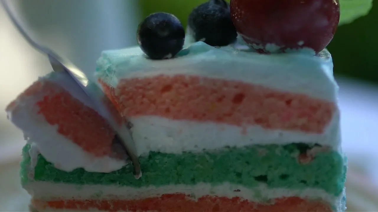 Fork pressing into the soft front edge of a homemade pandan layer cake