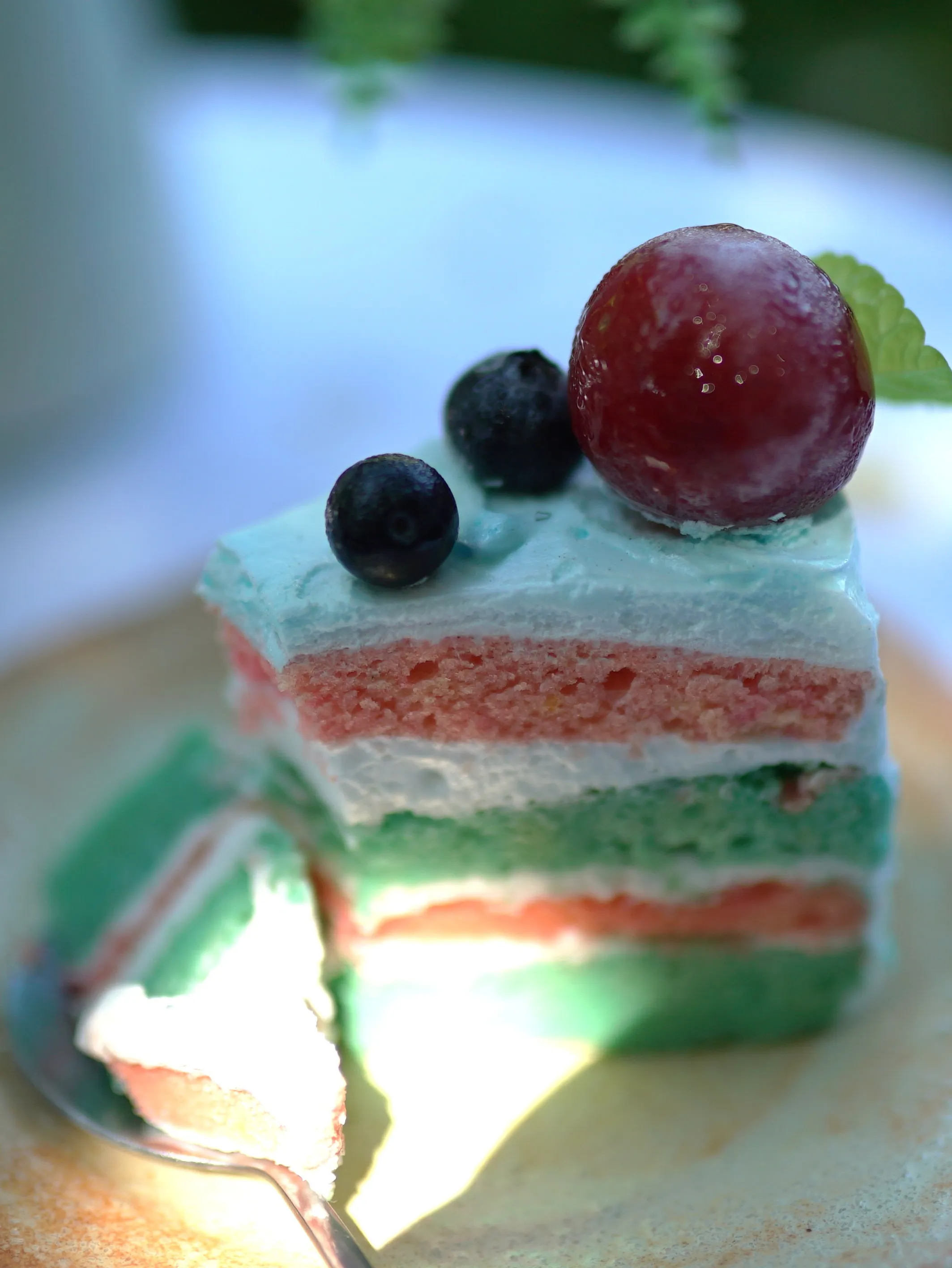 Cross-section of layer cake showing clean green white and pink sponge layers
