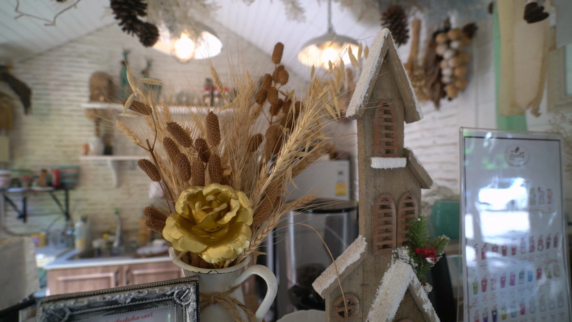 Shelf display with wheat stalks pinecones and miniature wooden church at Pa Dee in the Wild