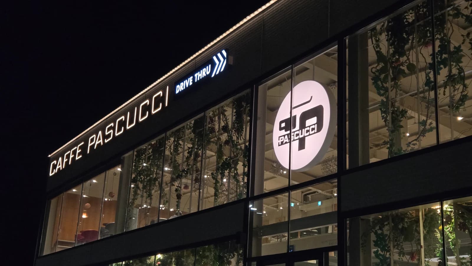 パスクッチ新灘津店のドライブスルー看板が夜間照明で輝いている