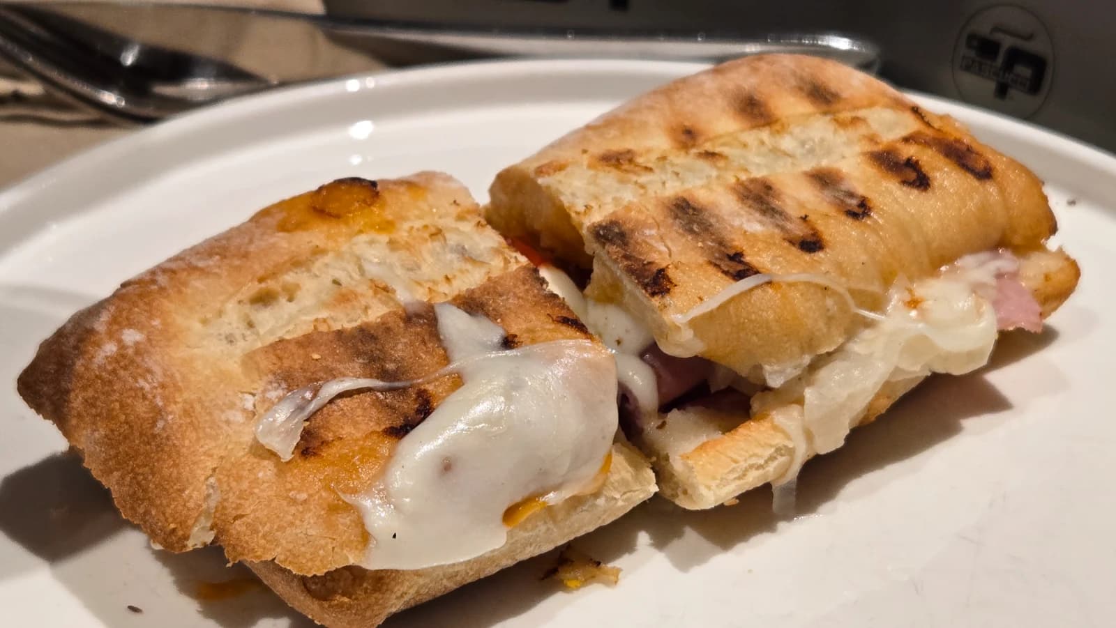 パスクッチのイタリアンクラシックパニーニ — 半分にカットされた断面からチーズがとろけ出ている