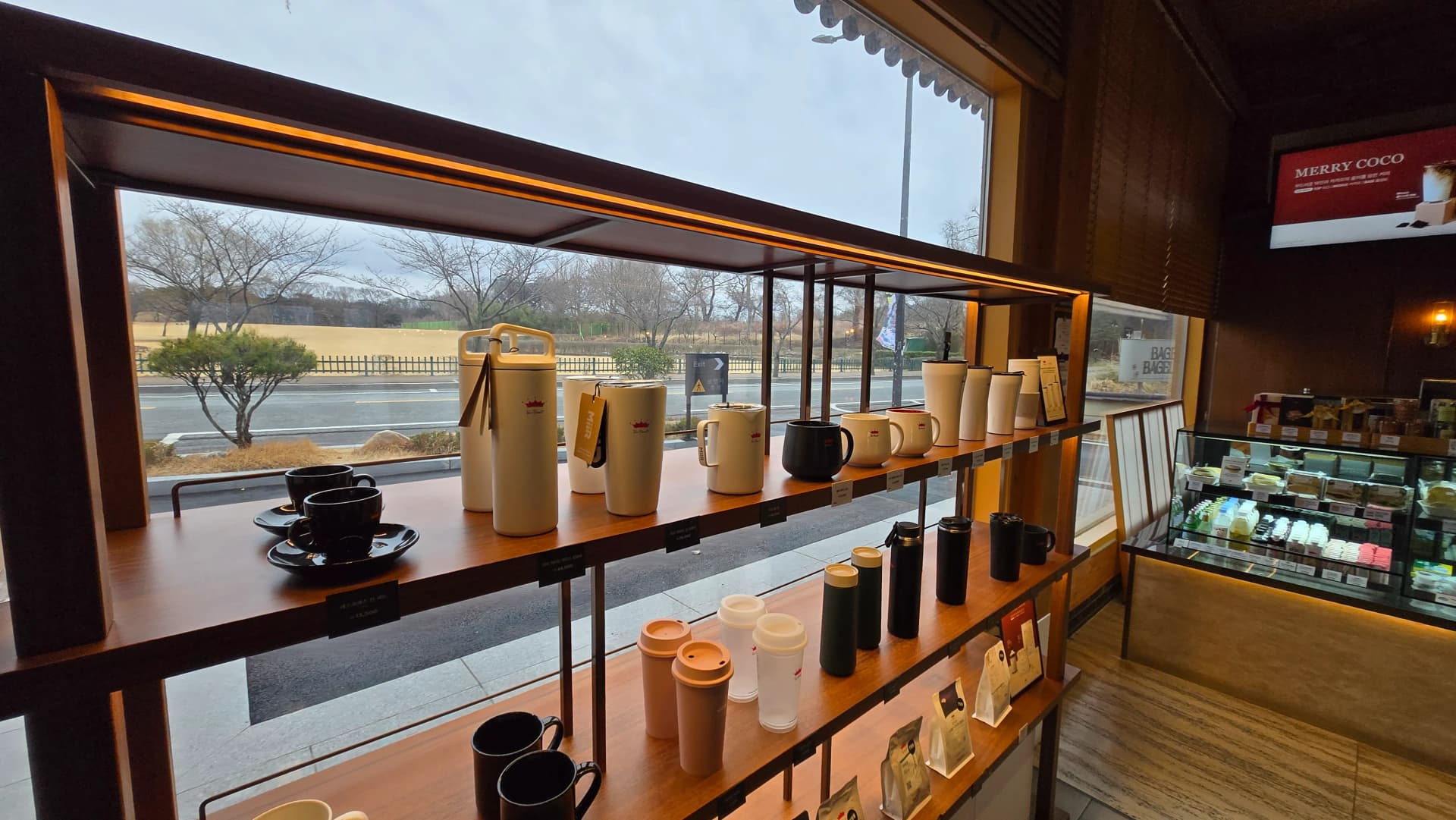 Kệ merchandise Paul Bassett Gyeongju với cảnh gò mộ Daereungwon ngoài cửa sổ | 하이제이에스비