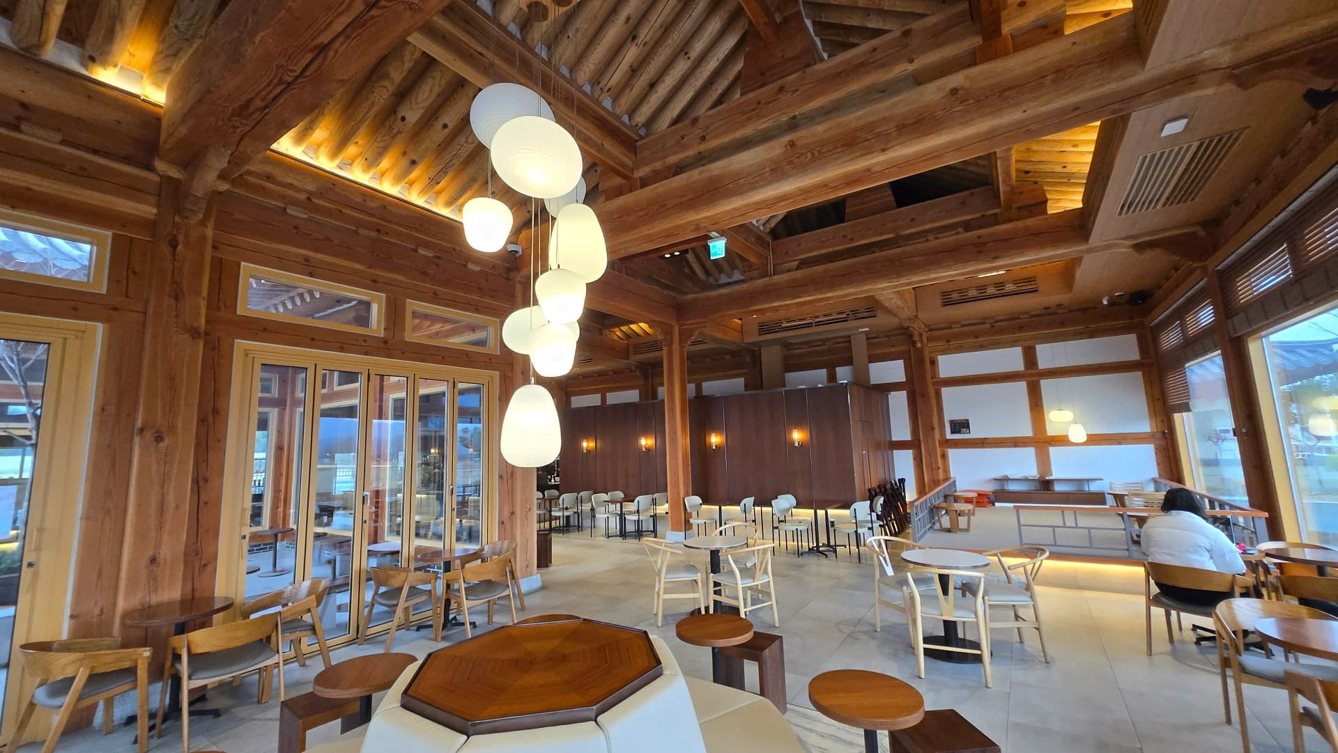 Toàn cảnh sảnh Paul Bassett Gyeongju — trần cao rui mè và đèn trung tâm trong không gian rộng | 하이제이에스비