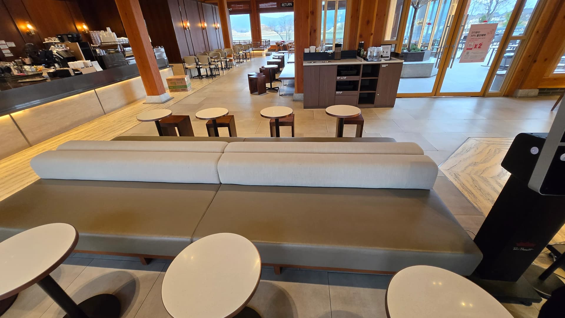 Sofa bát giác Paul Bassett Gyeongju với view cửa sổ — phố Gyeongju và mái hanok | 하이제이에스비