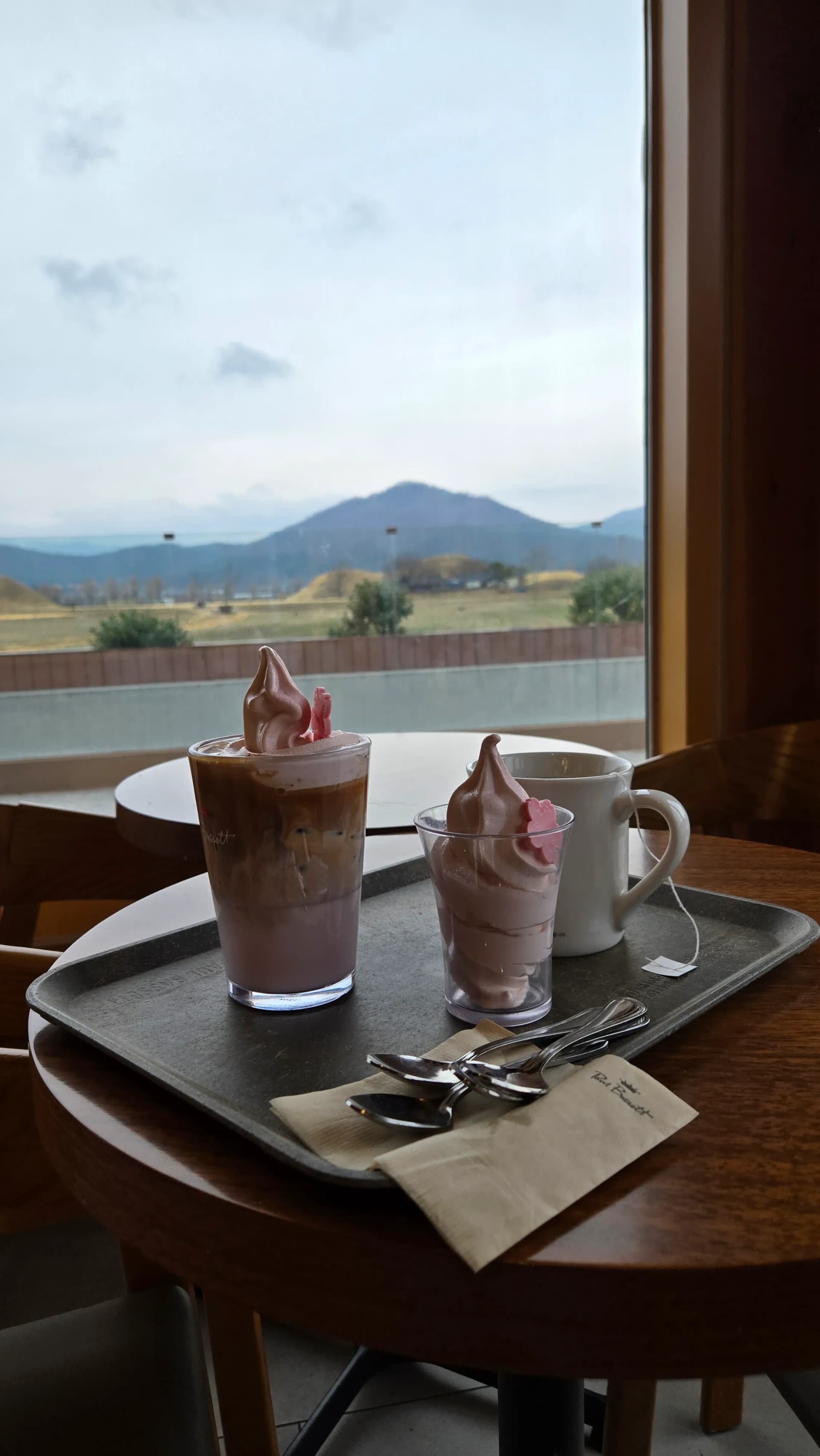 Đồ uống trên bàn cửa sổ Paul Bassett Gyeongju — phông nền view gò mộ | 하이제이에스비