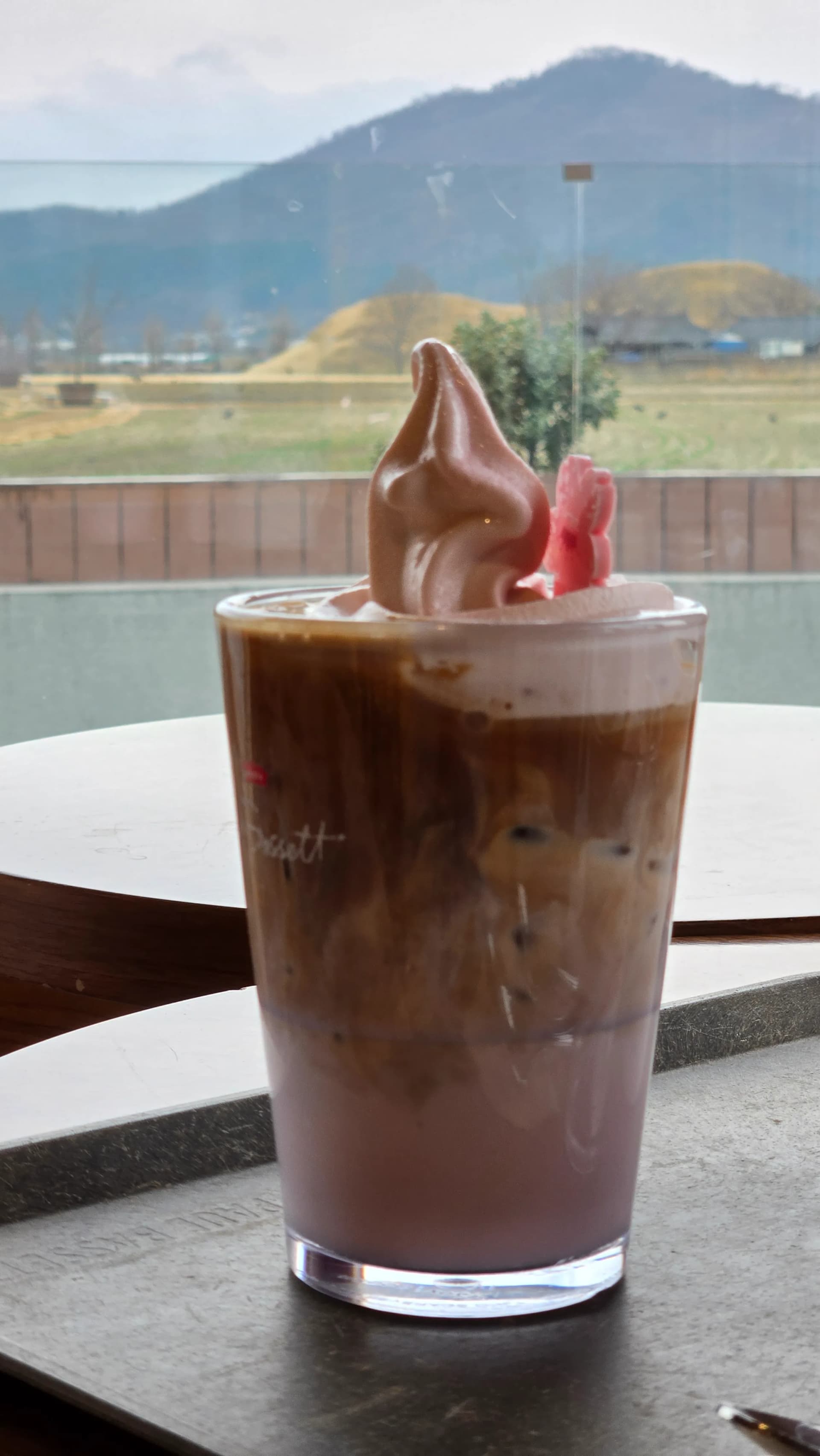 Ly cà phê cạnh cửa sổ Paul Bassett Gyeongju với view gò mộ cổ | 하이제이에스비