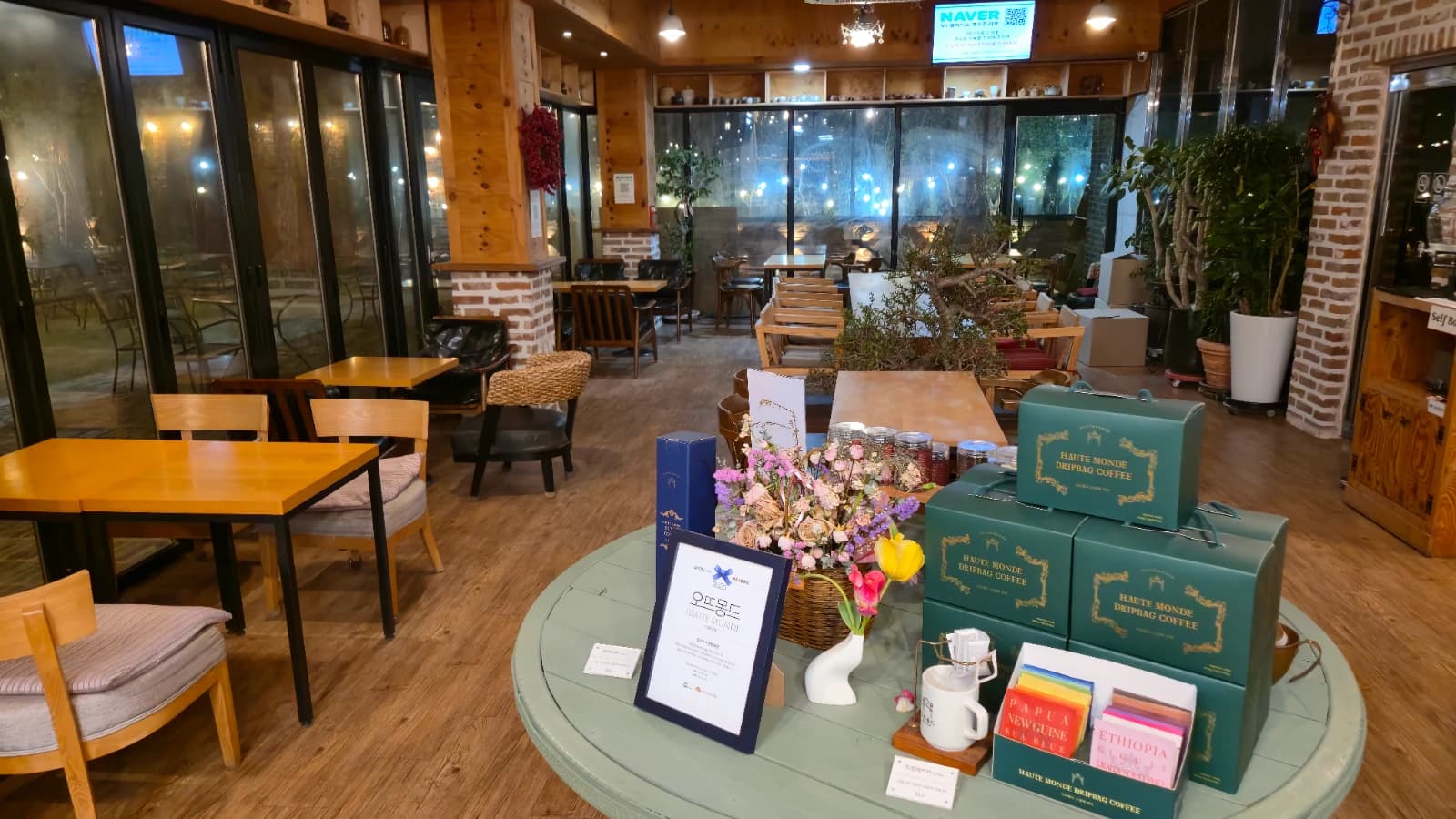 오뜨몽드 입구 쪽 홀 나무 테이블과 드립백 커피 박스 디스플레이