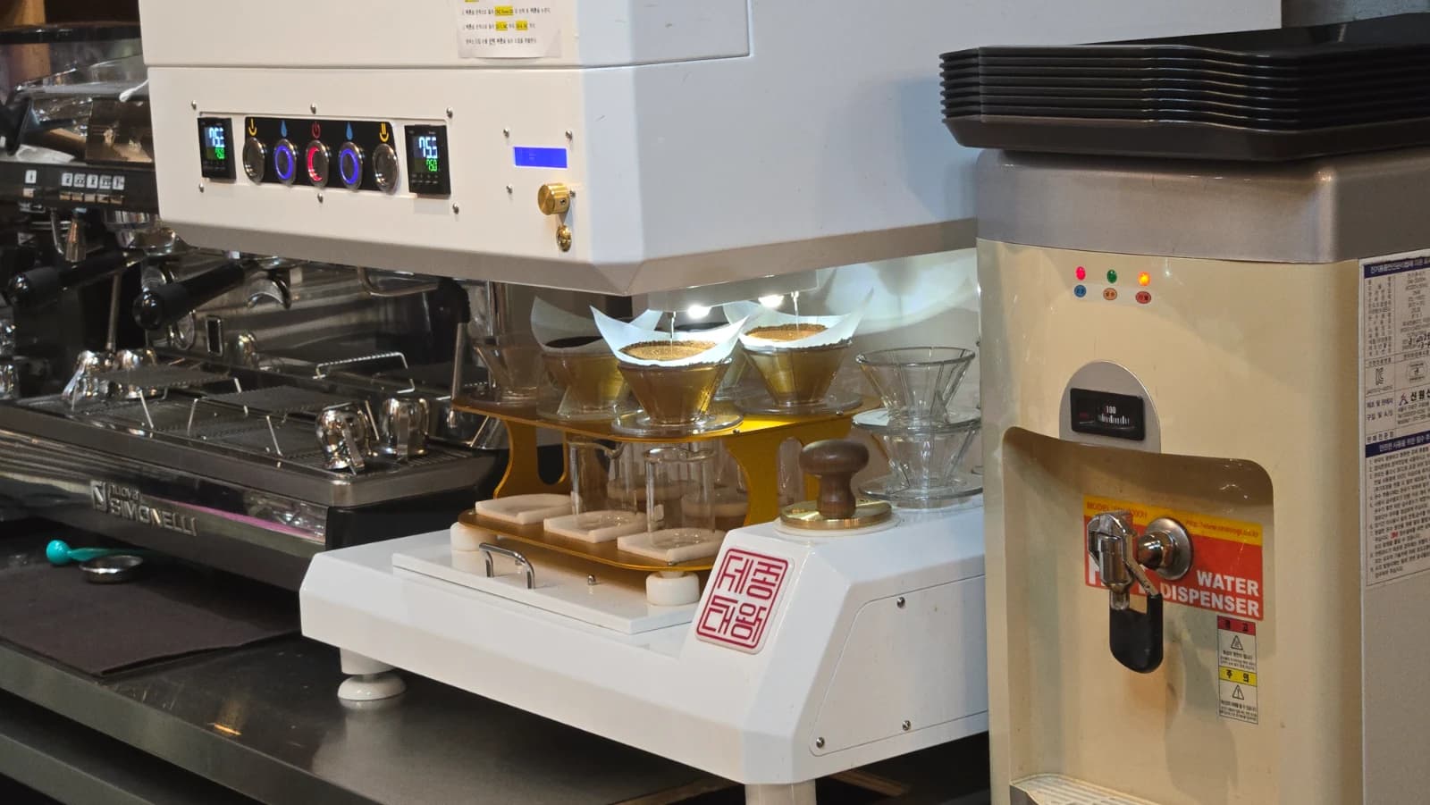 시모넬리 에스프레소 머신과 자동 드립 머신이 나란히 놓인 오뜨몽드 장비 구성