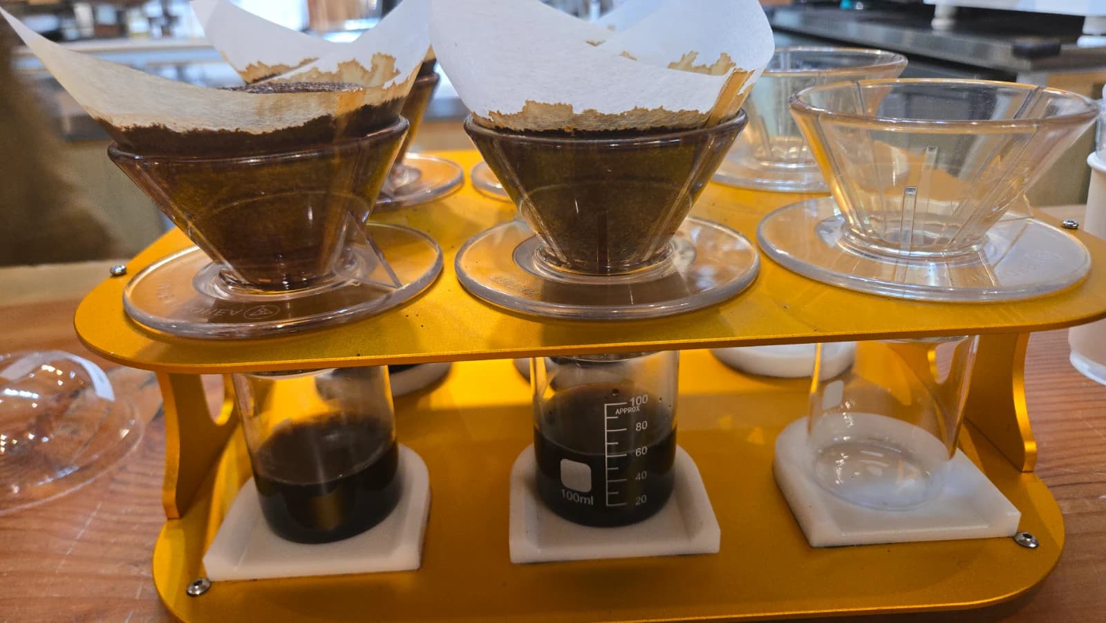 드립 추출 완료 후 비커에 담긴 커피 필터 안 원두가 부풀어 오른 모습