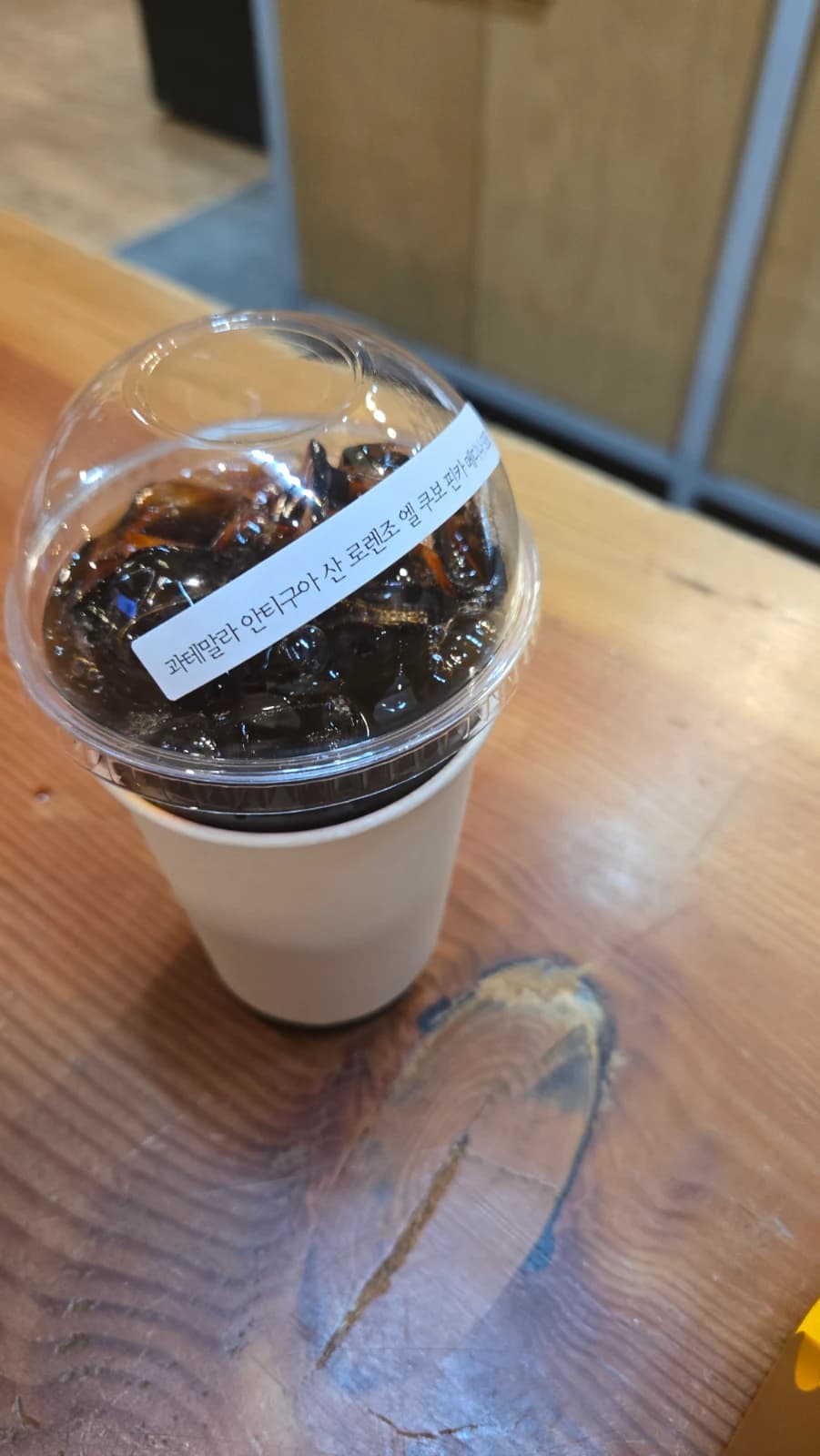 오뜨몽드 드립 커피 아이스 컵에 원두 이름 라벨이 붙어 있는 모습