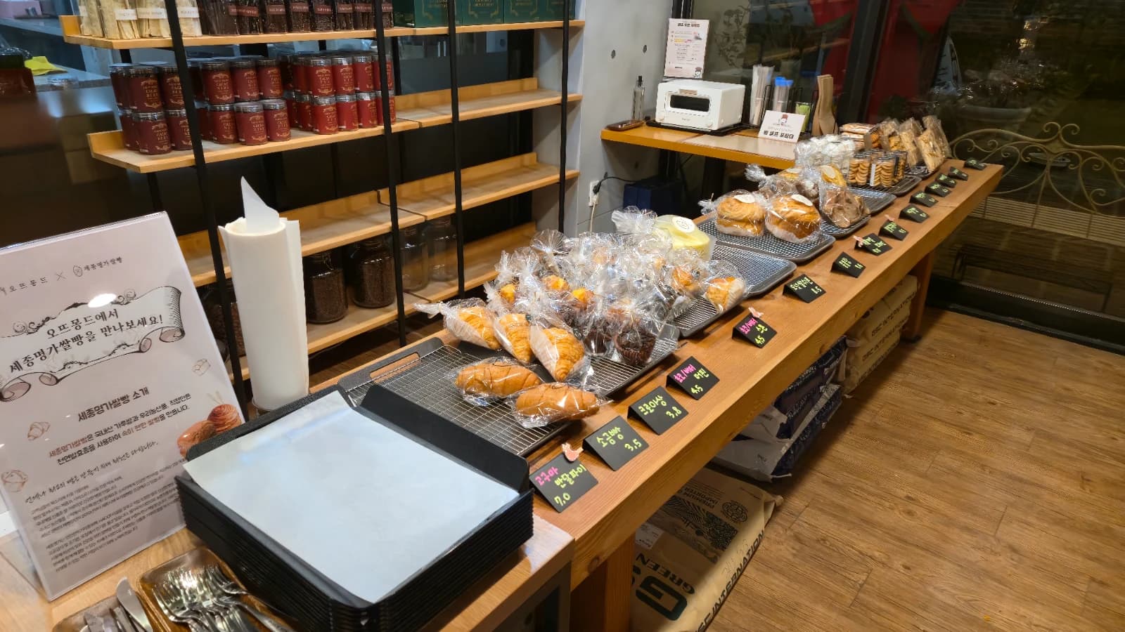 오뜨몽드 카운터 옆 빵 진열대와 세종명가빵빵 협업 안내판