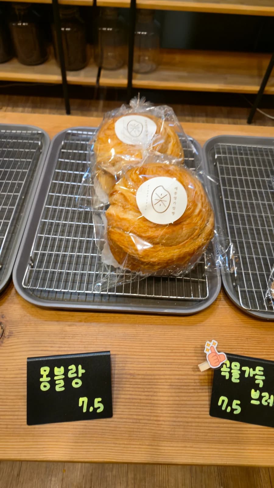 오뜨몽드 자체 원두 캔과 빵 진열 선반 전체 모습