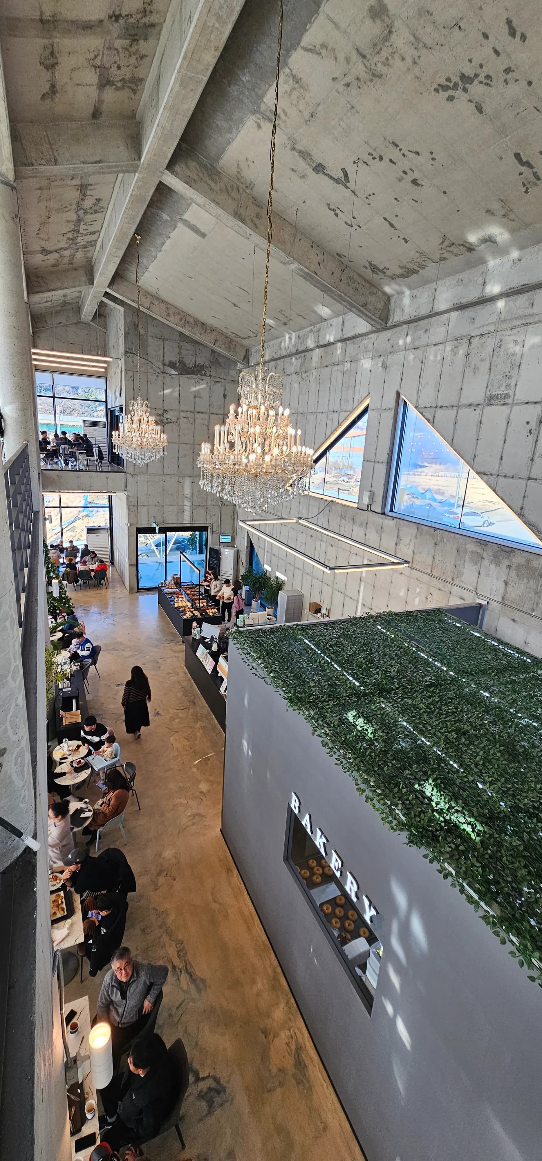 Madirisha mawili ya umbo la pembe tatu ndani ya Semo Cafe, mwanga wa asili na muundo wa kiviwanda | 하이제이에스비