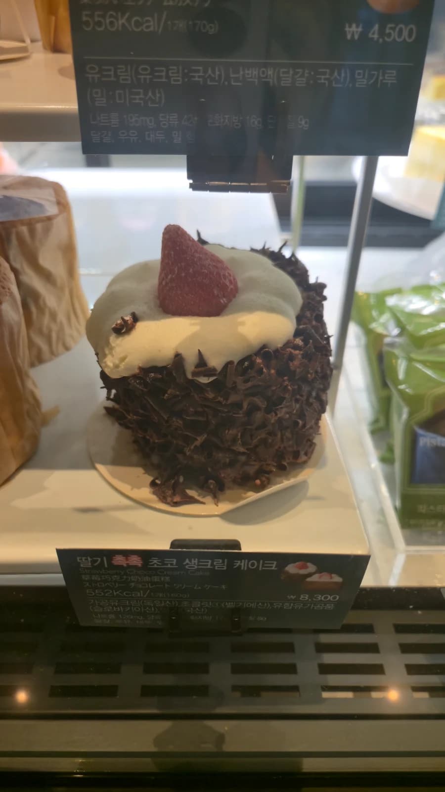 Seção de bolos do Starbucks coreano com bolo de morango com chantilly e macaron de pistache