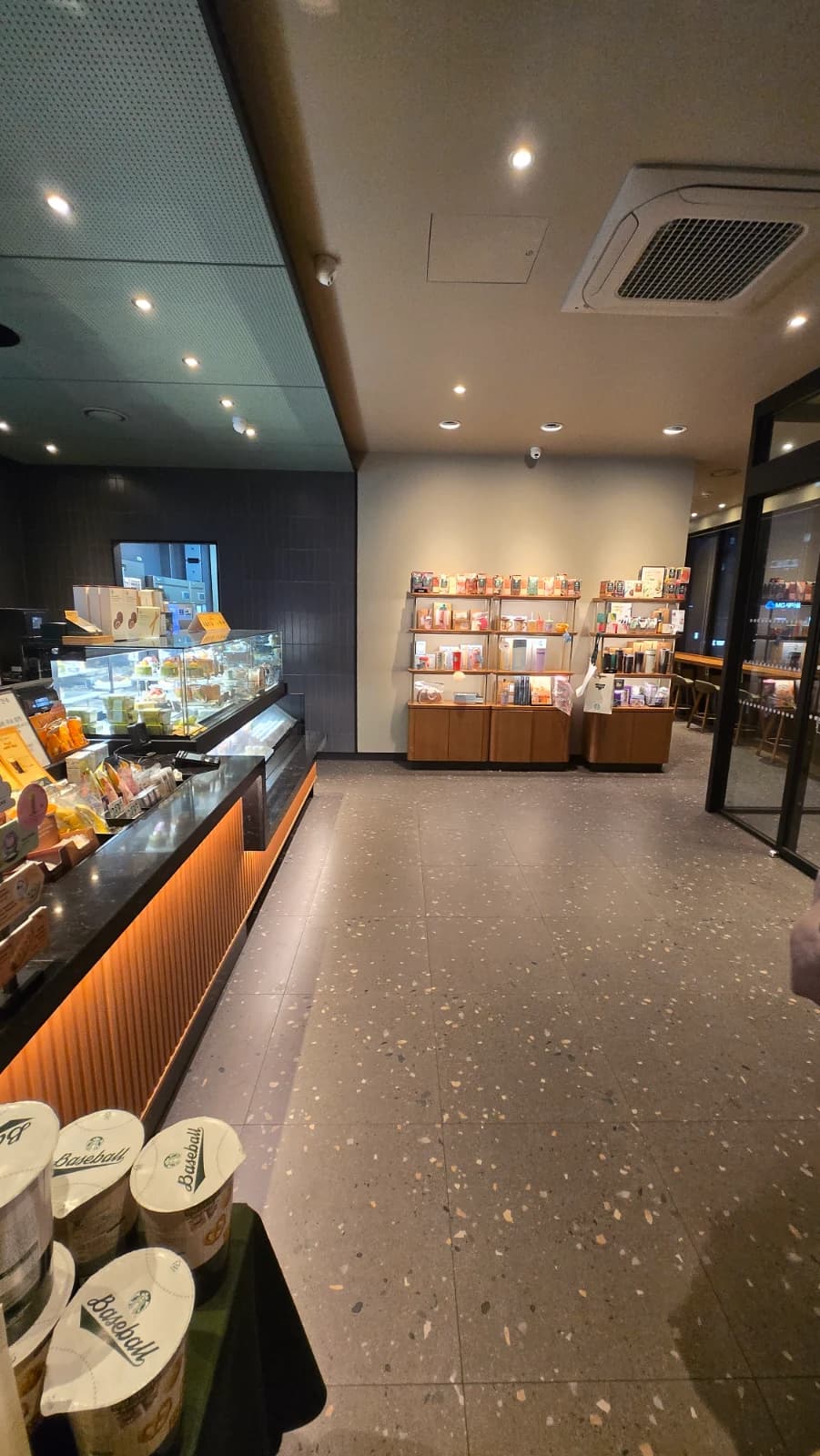 Interior de um Starbucks coreano com piso de terraço e iluminação embutida