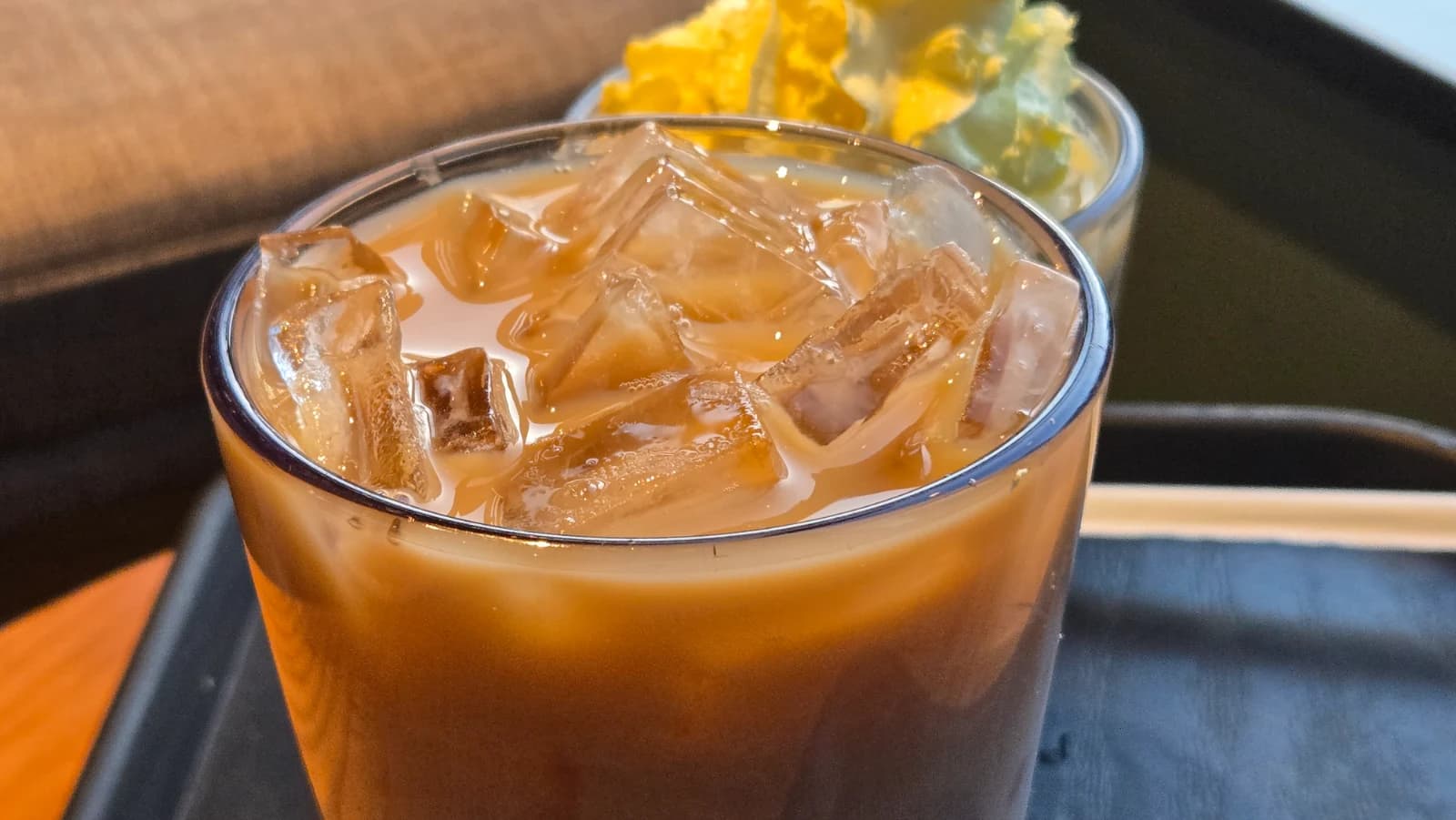 Close do sweet milk coffee do Starbucks coreano, bebida gelada de tom alaranjado