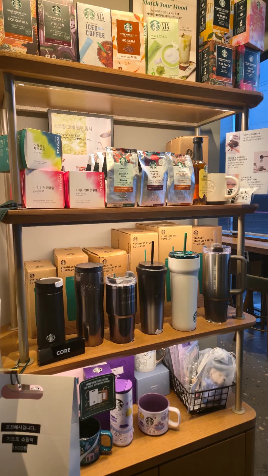 Seção de merchandise do Starbucks coreano com tumblers, cold cups e pacotes de café