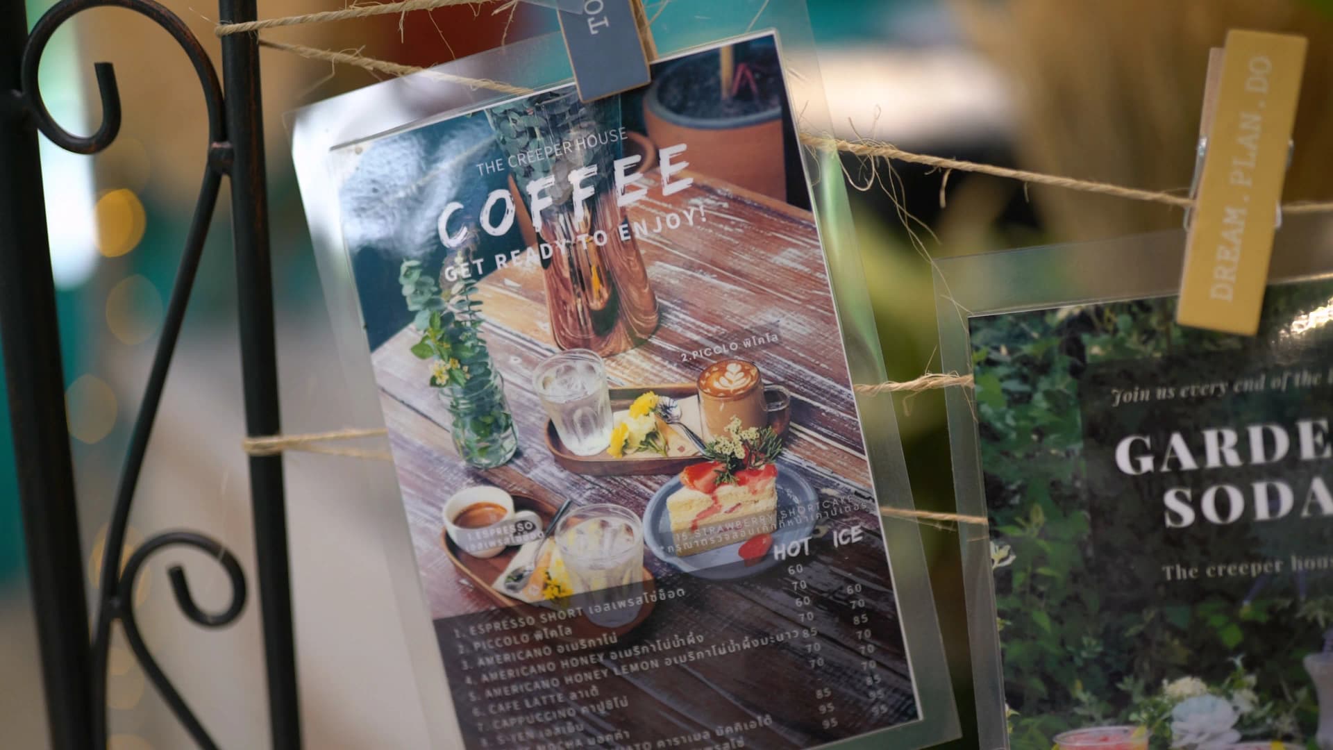 Menu cards clipped with wooden pegs to an iron stand featuring GARDEN SODA and HAPPY DAY MILK options