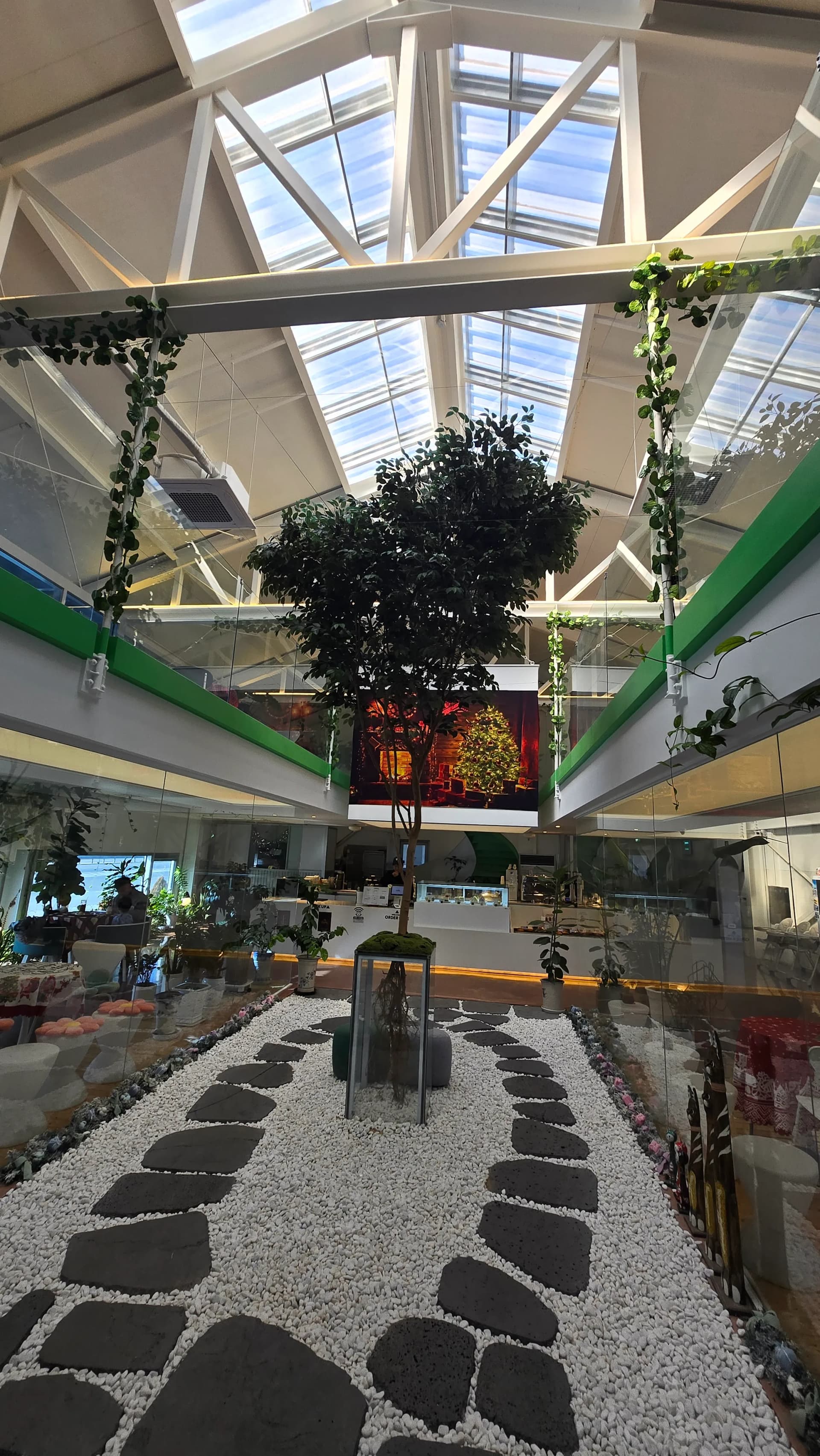 커먼비 내부 인테리어 - 화사한 조명과 식물이 어우러진 아늑한 카페 공간 | 하이제이에스비