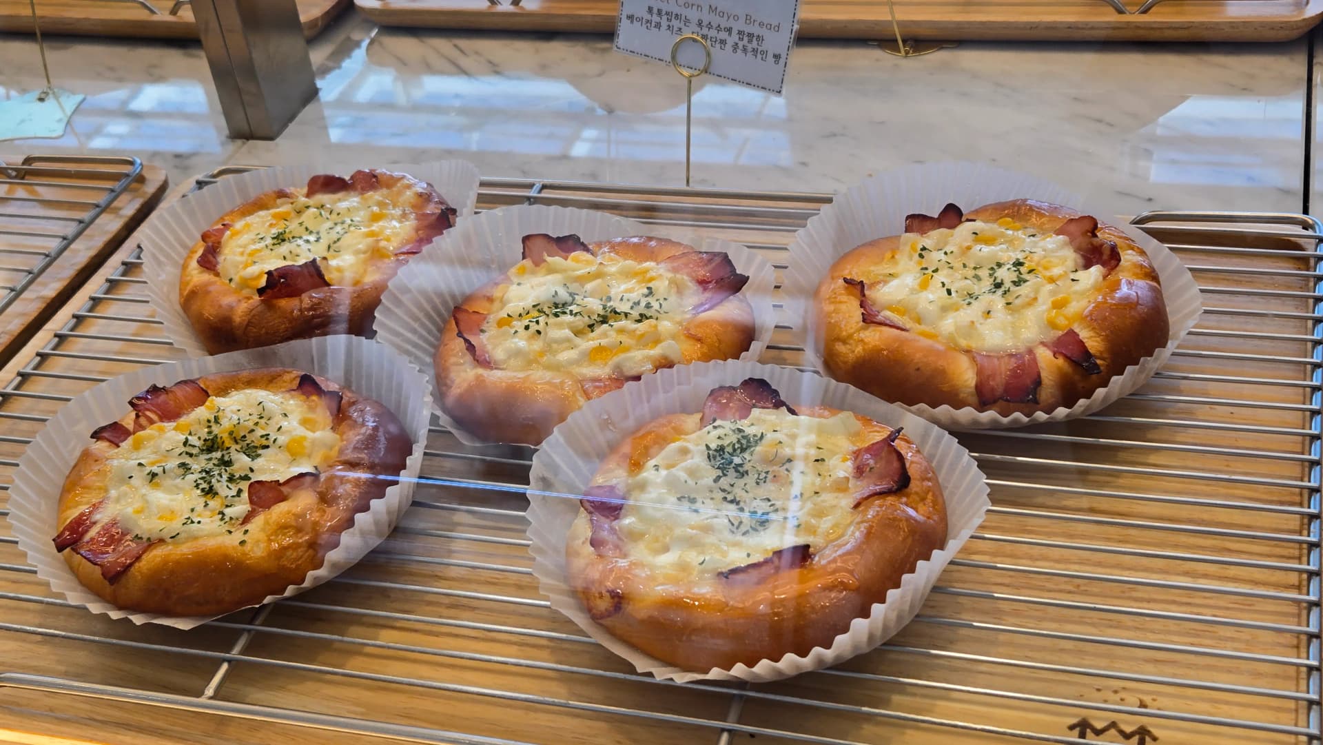 Corn mayo bread nwere bacon edge, cheese na corn jupụtara n’elu, na parsley topping | 하이제이에스비