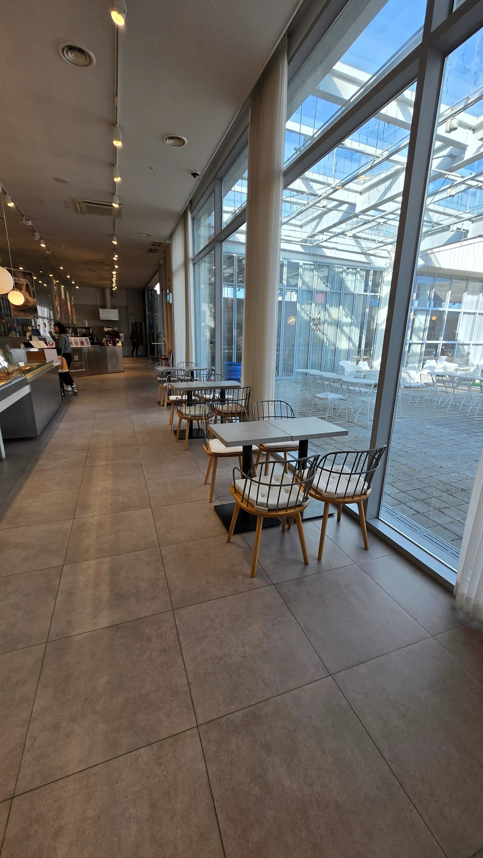 Oche osisi nwere cushion a haziri n’ahịrị n’akụkụ nnukwu windo iko n’ime Ean Terrace | 하이제이에스비