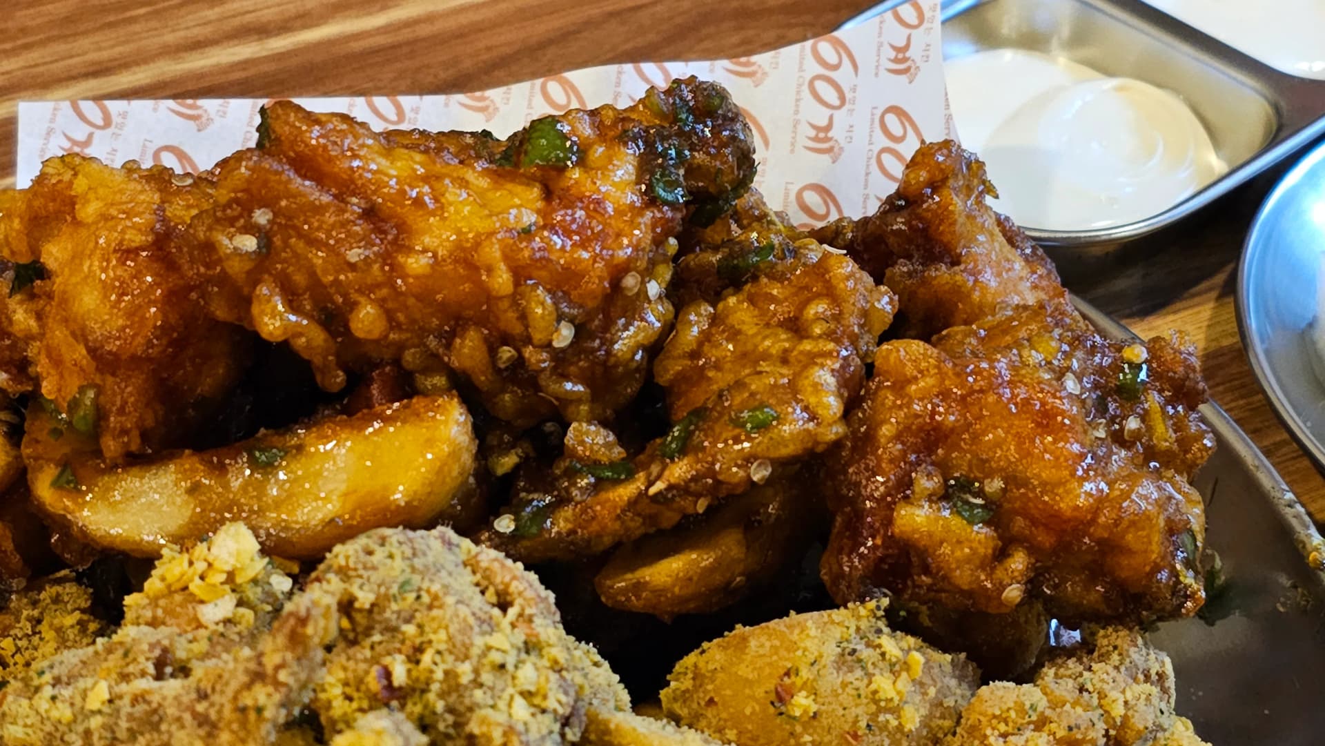 لقطة قريبة لدجاج الفلفل الحار من 60 غي تشيكن مع صلصة حمراء لامعة وقطع فلفل أخضر حار فوقه