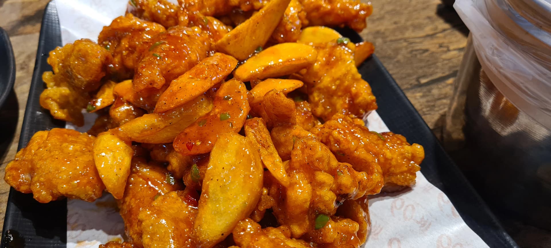 دجاج الـ6 ثوانٍ من زاوية أخرى يظهر فيها قطع الدجاج بدون عظم وشرائح البطاطا لامعة بالصلصة الحمراء عن قرب