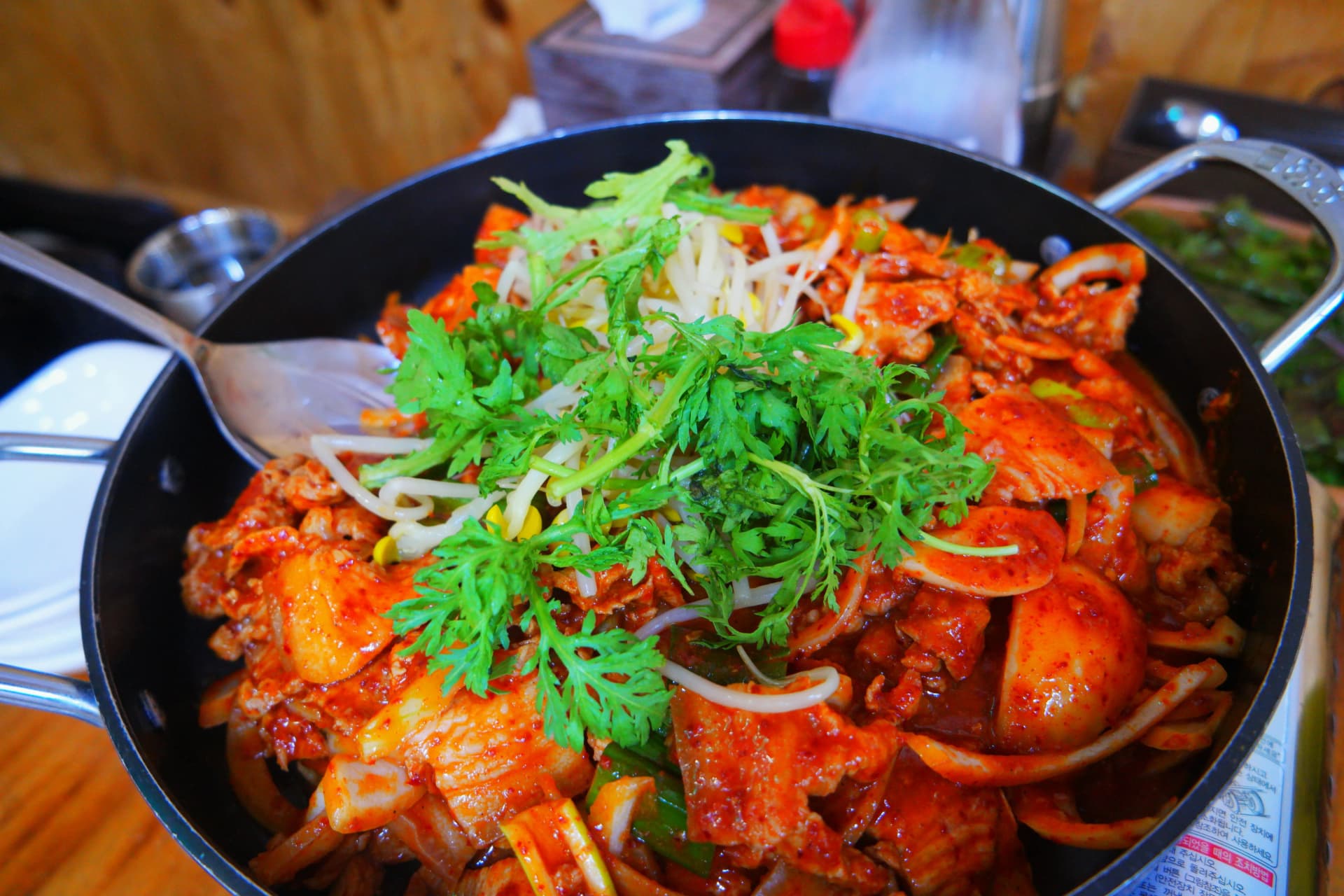 Солонгосын энгийн сет хоолны газарт гарч ирсэн гахайн дүүрүчиги тогоо - ссүггат, буурцгийн соёо, гахайн мах, кимчи дүүрэн тогоотой ширээний хоол